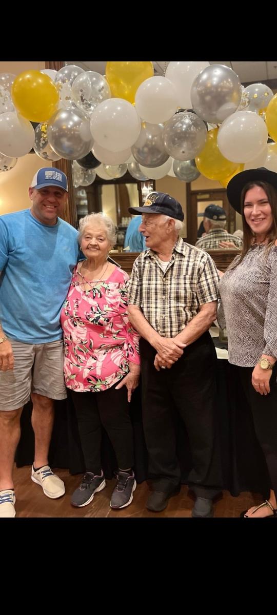 Four family members pose together in a restaurant, celebrating a joyful family event.