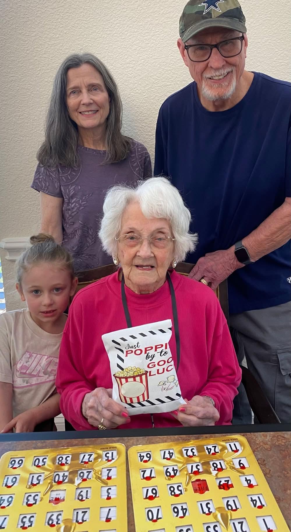 Grandmother surrounded by family members celebrating together in a comfortable home environment.