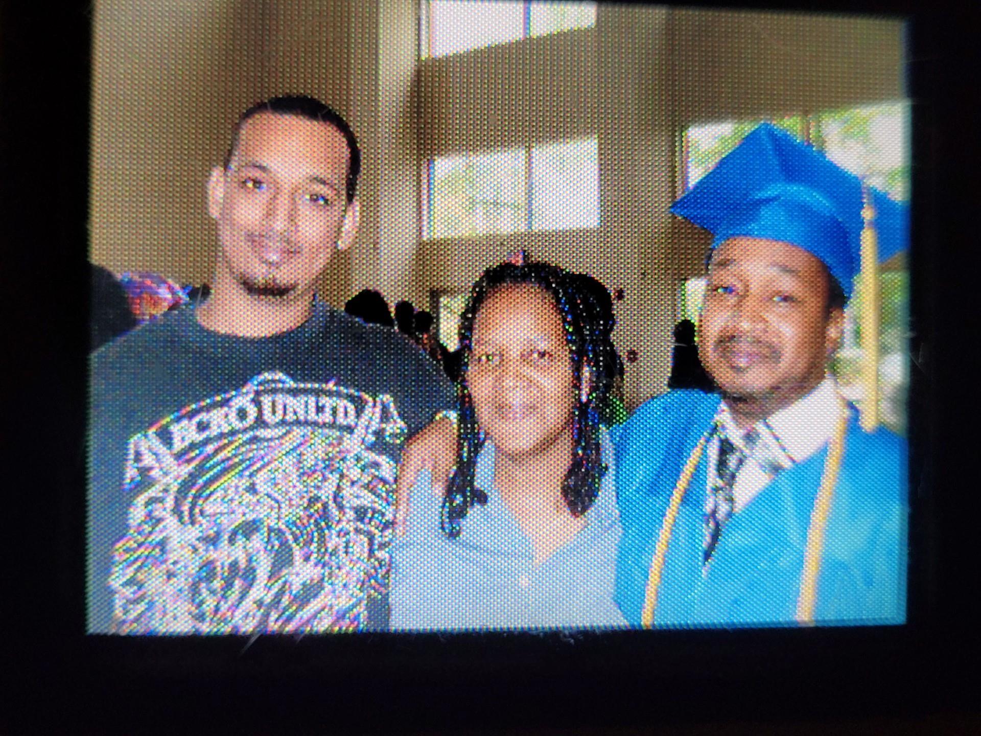 Family members proudly pose together after a graduation ceremony in a school hall filled with joy.