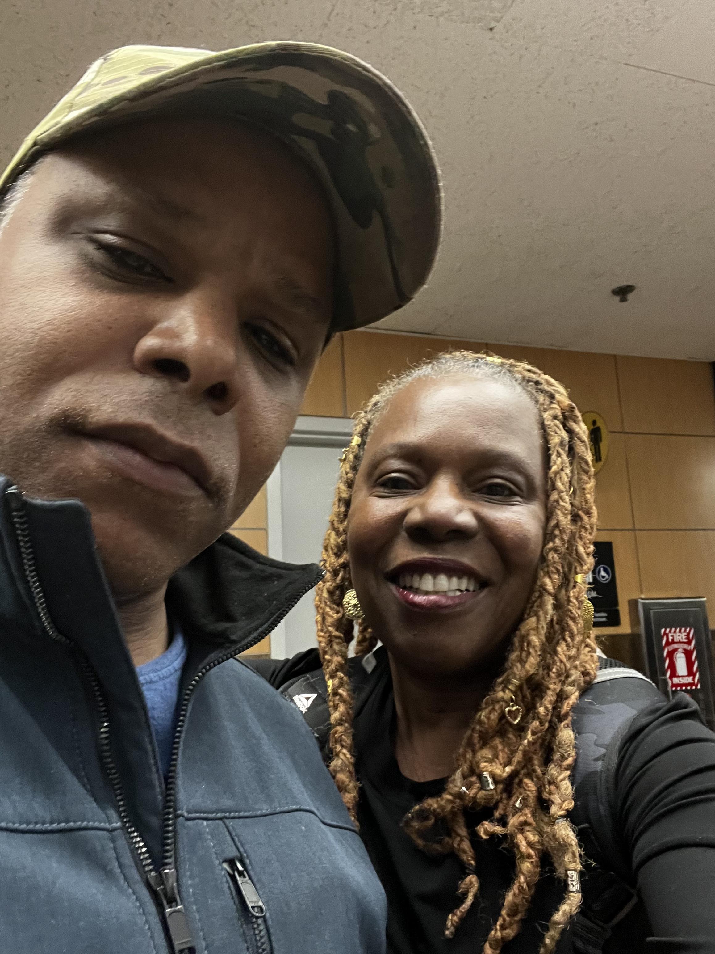 Two friends share a joyful moment as they pose for a selfie during a lively community gathering.