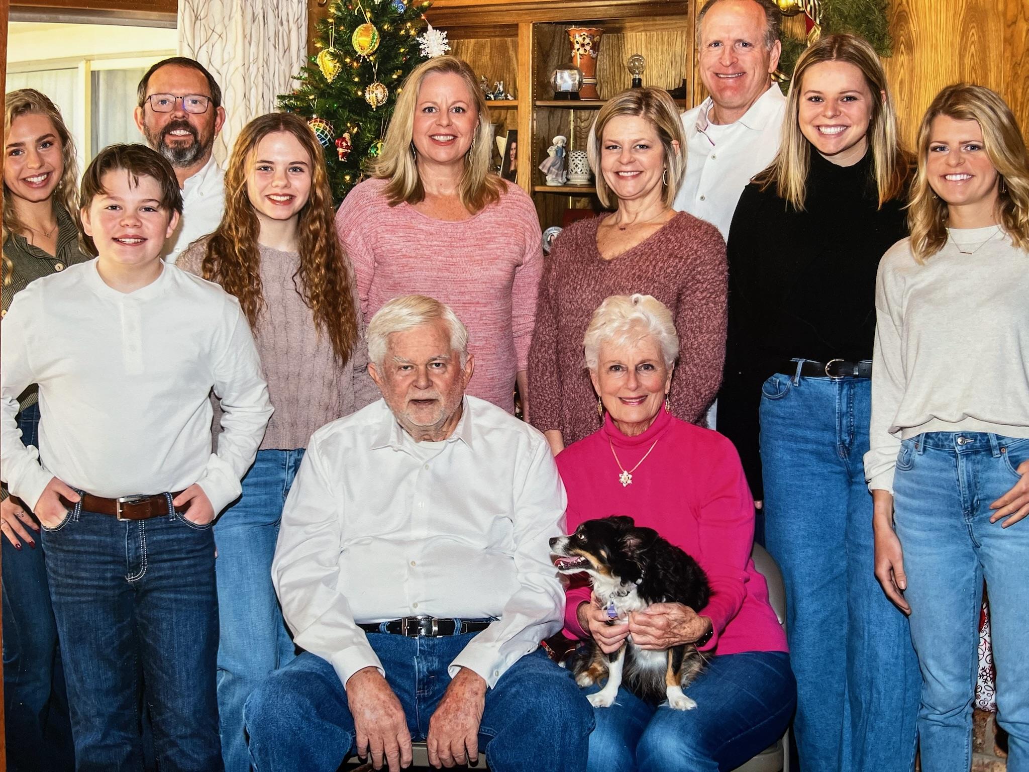 Family members gather around for a cheerful holiday celebration in their cozy living area.