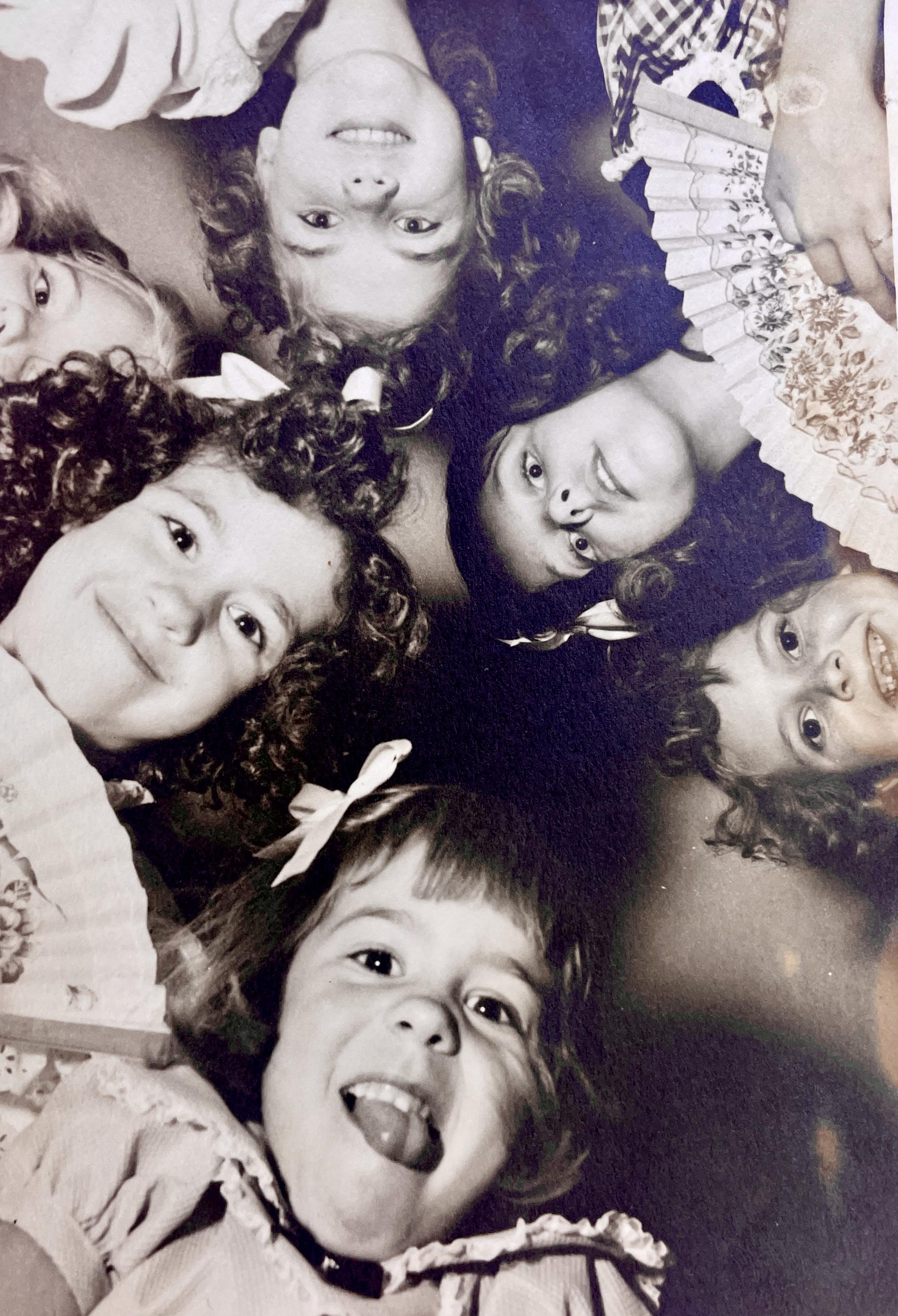 Group of cheerful young girls with curly hair sharing laughter and joy during a playful moment