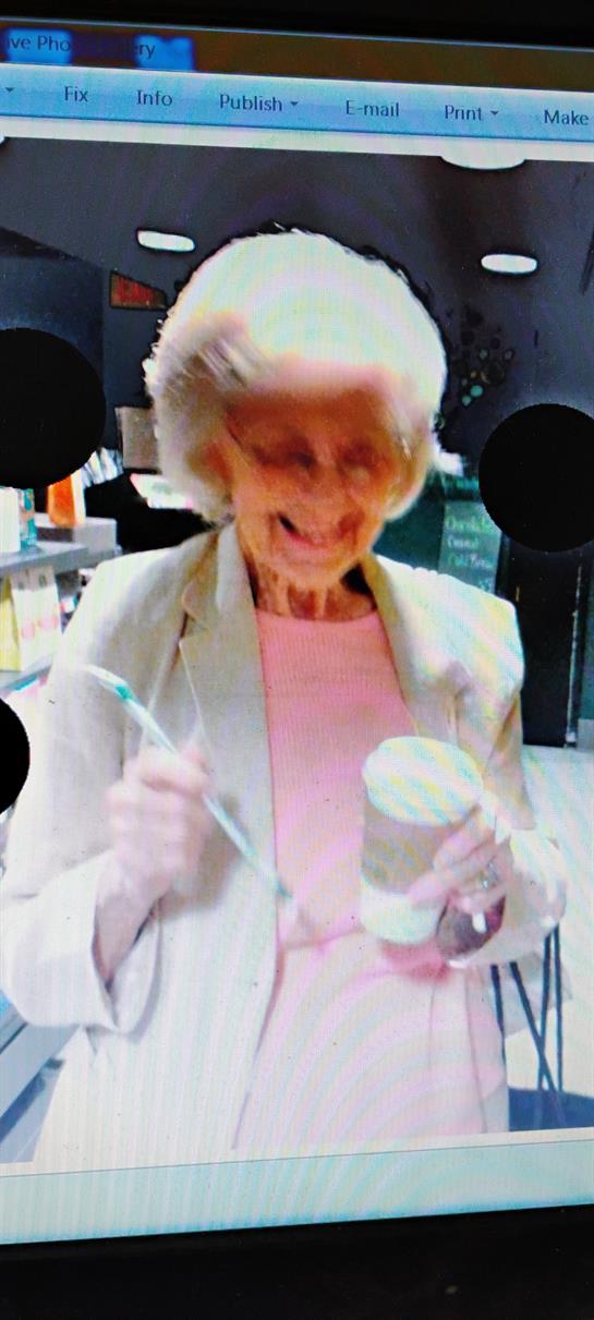 An old woman holding a toothbrush and a cup