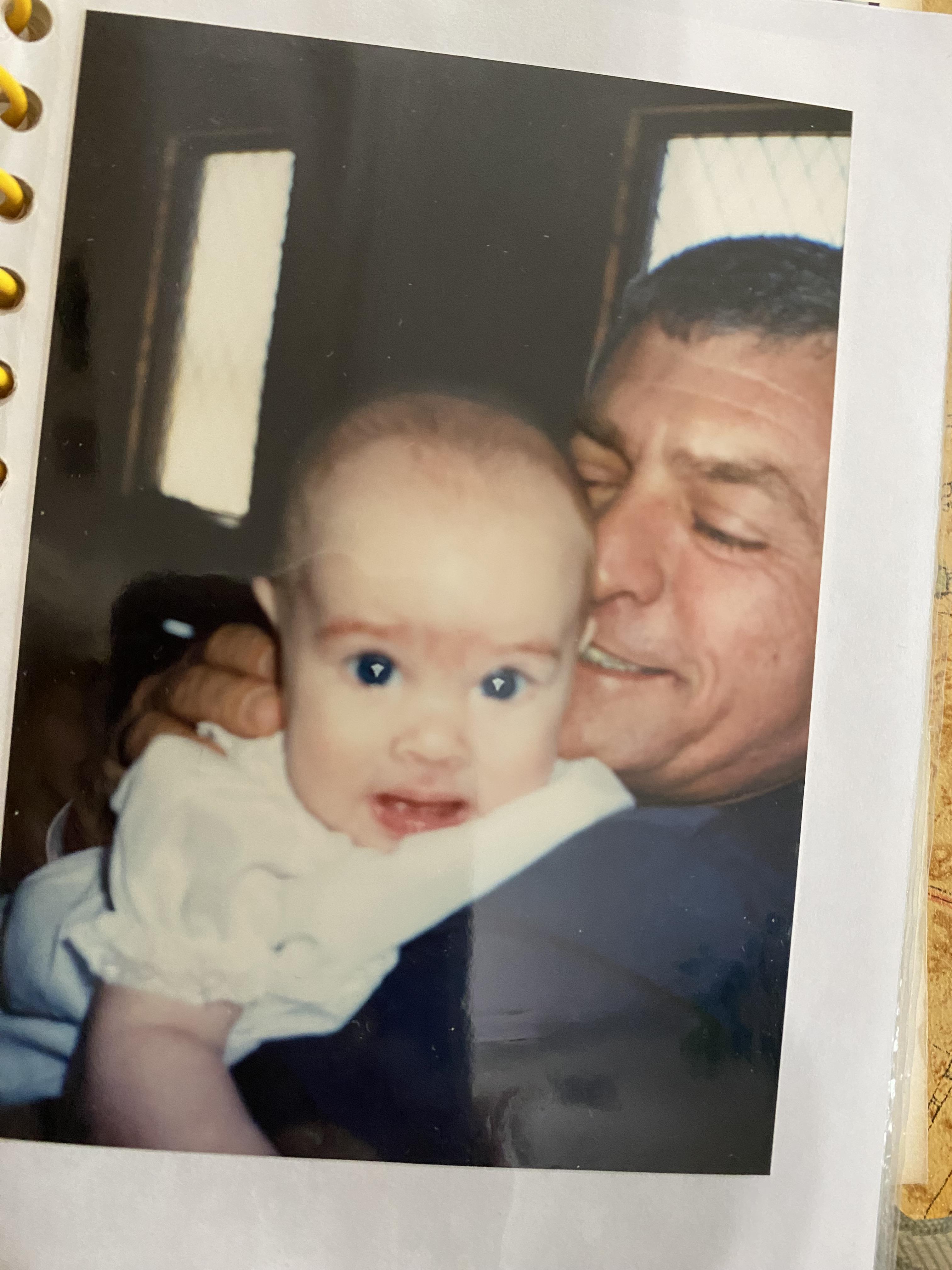 A joyful interaction between a father and his baby girl, highlighting their bond indoors.
