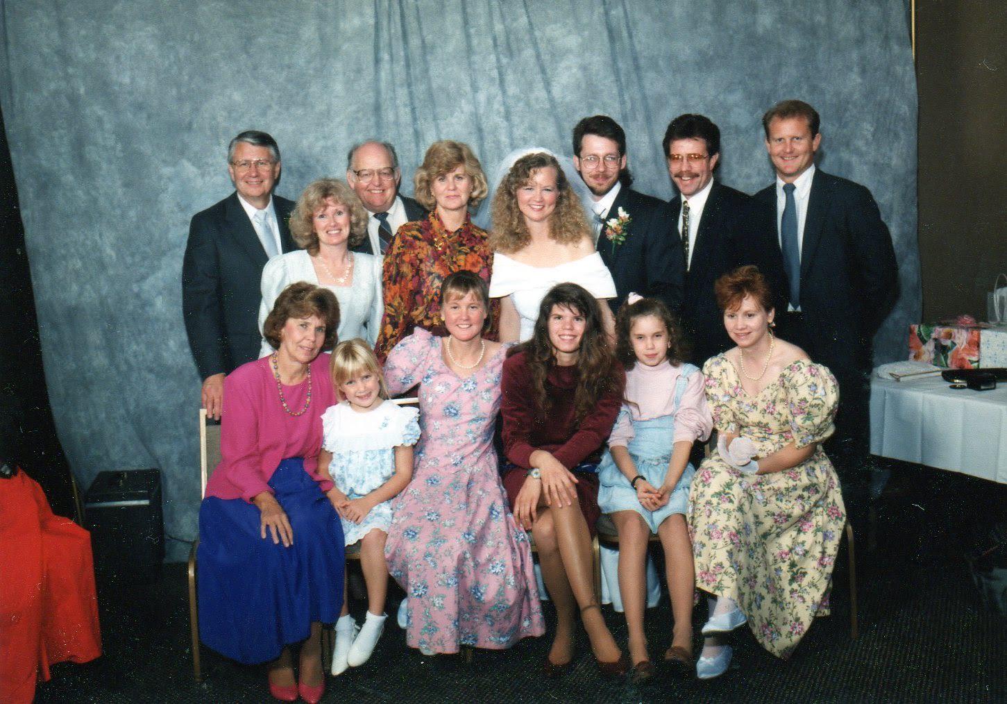 A large group of family members gathers for a formal portrait, showcasing their smiles and outfits.