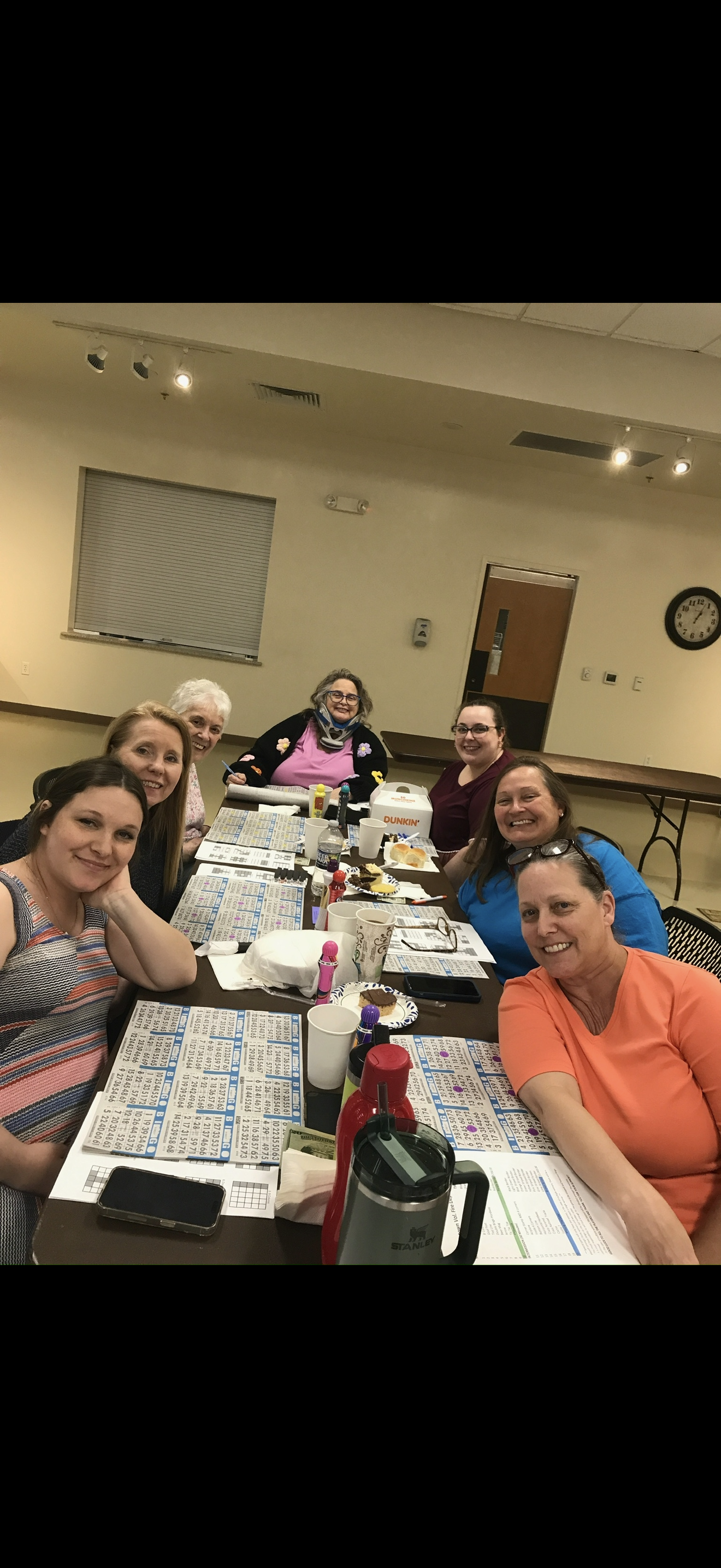 Friends gather around a table sharing laughter while playing bingo during an enjoyable evening.