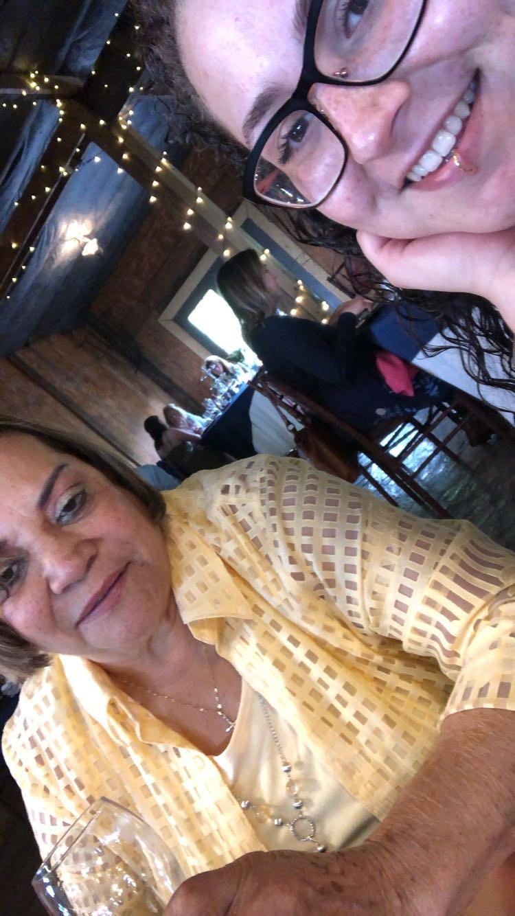 Two women share a moment together in a lively restaurant, enjoying food and conversation.