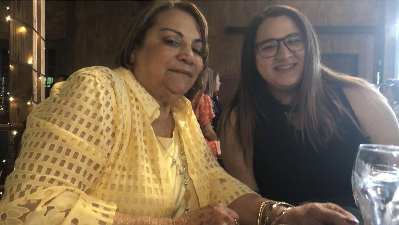 Two women share smiles and laughter while celebrating family connections in a warm atmosphere.