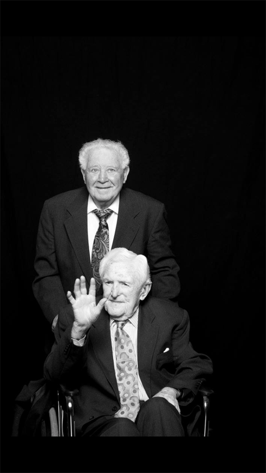 A man in a suit and tie holding a hand up