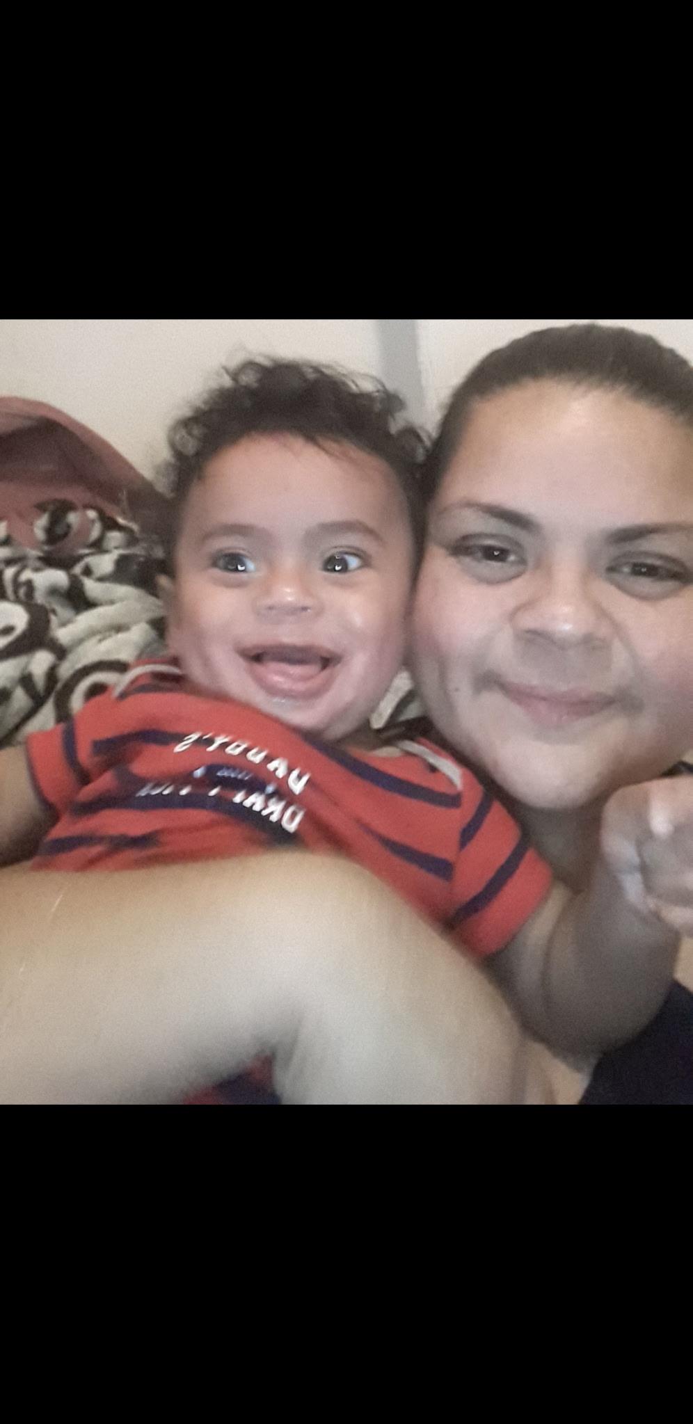 Mother and baby smile together, enjoying a fun moment on a lazy afternoon at home.