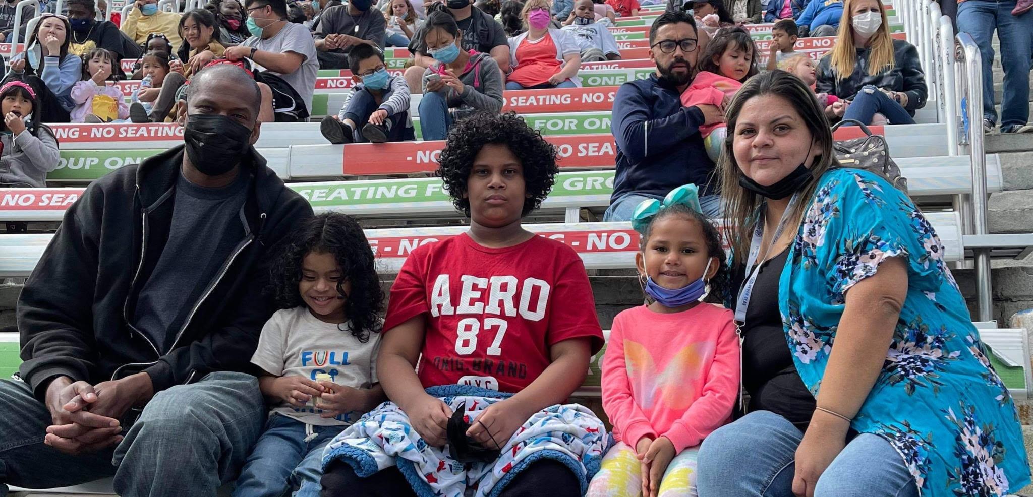 Families gather at an outdoor venue, engaging in activities and enjoying each other's company.