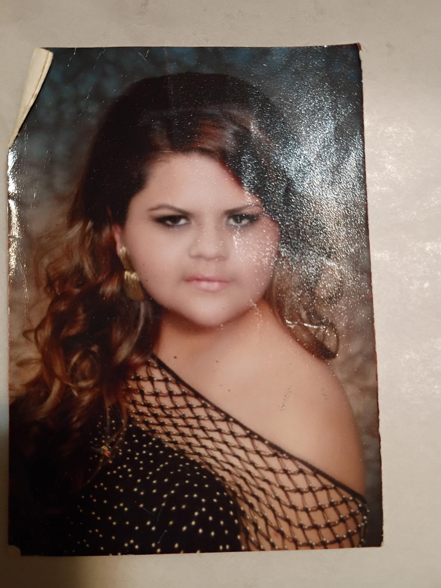A young girl poses in a stylish dress with curls at a photography studio, showcasing elegance.