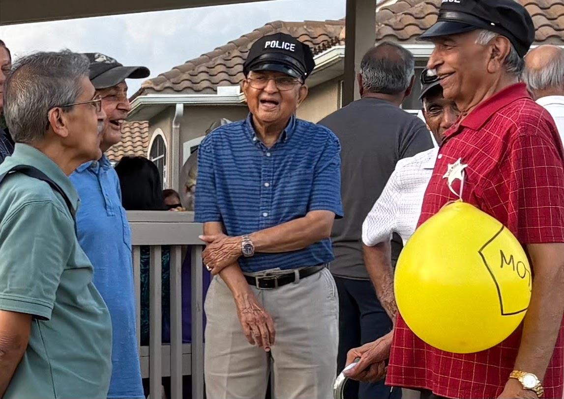 Older men in hats enjoying lively talks at a neighborhood community gathering.