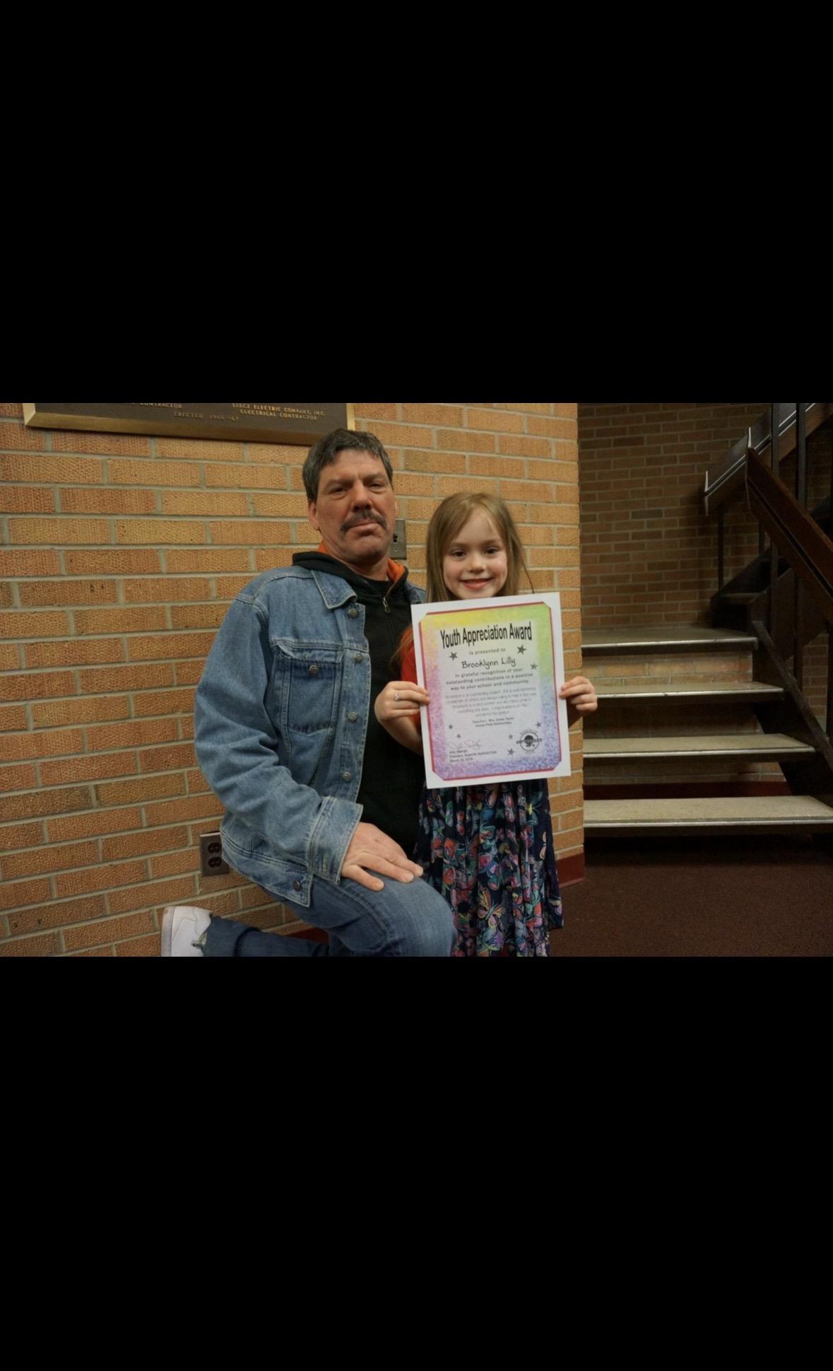 A man and a girl holding a certificate