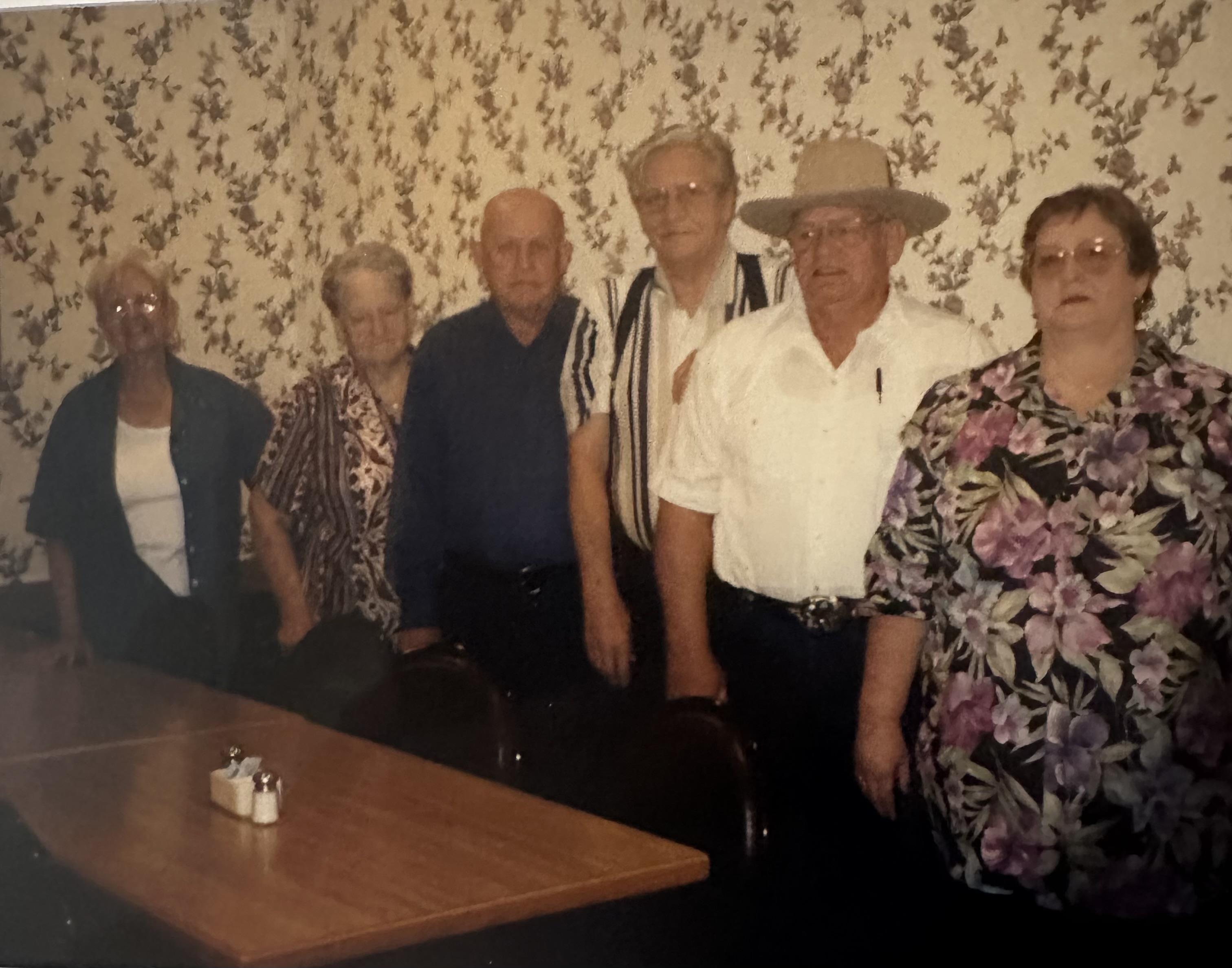 Seniors pose together in a dining area, sharing moments during a community gathering.