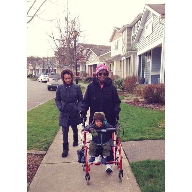 A woman pushing a child in a walker