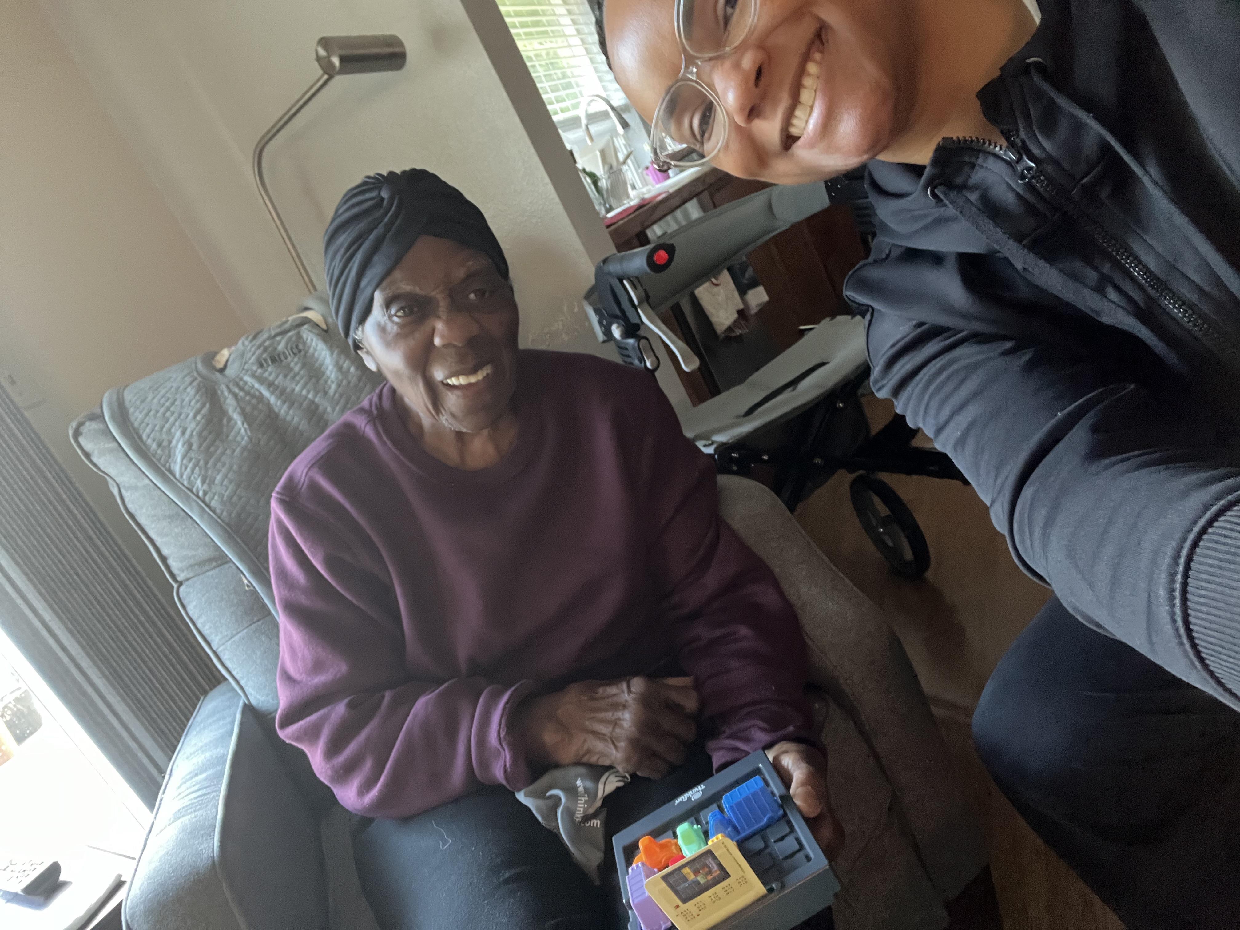 Two family members share laughter and fun while engaging with a tablet in a cozy living room.