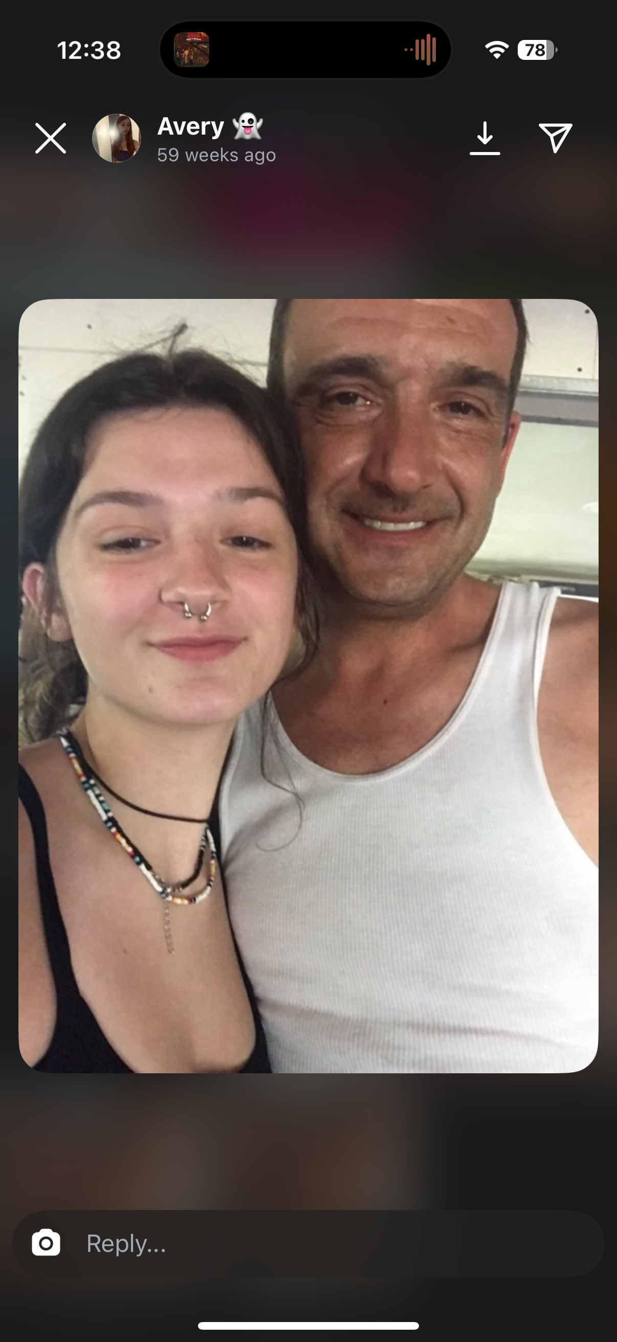 Two friends share a joyful moment, smiling happily in a warm, sunlit environment.