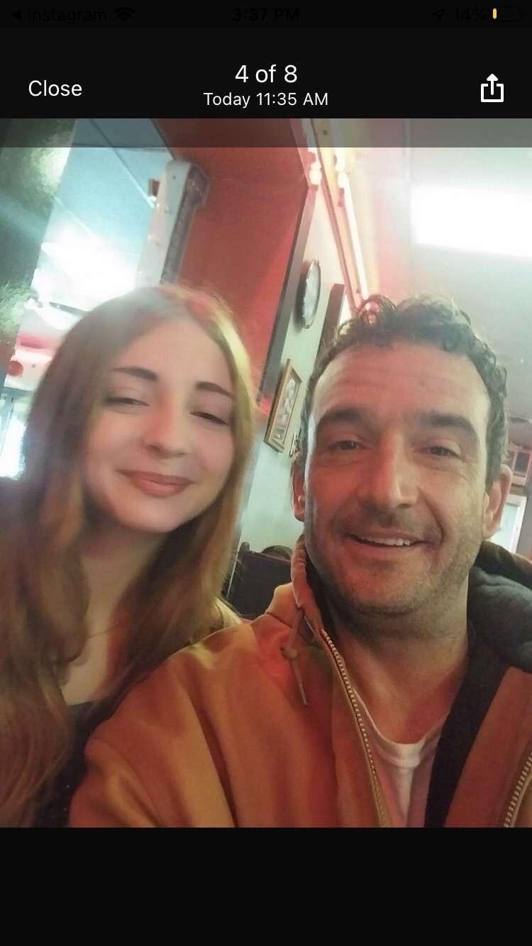 Two friends pose for a selfie while enjoying conversation and coffee in a lively cafe setting.