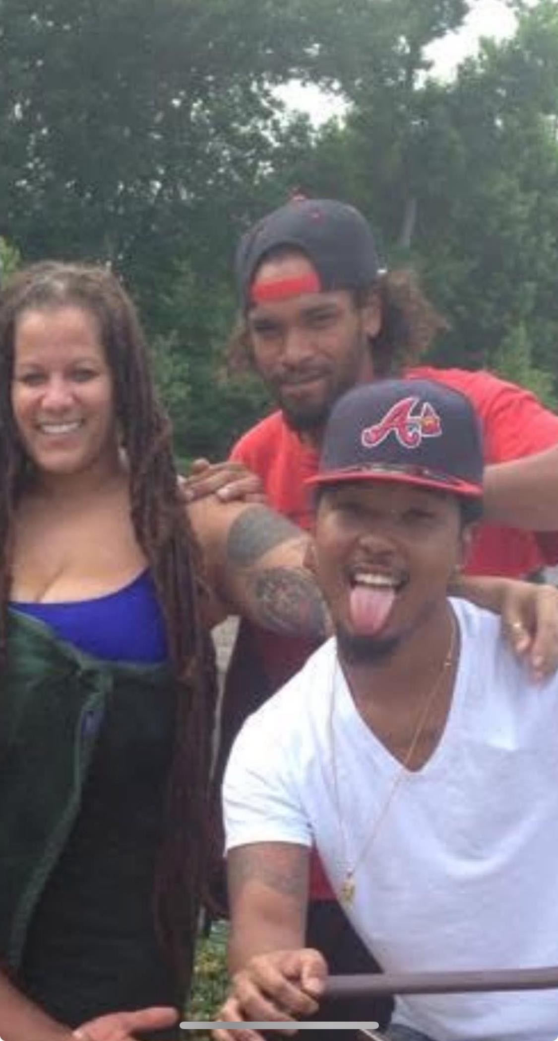 Three friends enjoy a warm summer day outdoors, smiling and laughing together playfully.