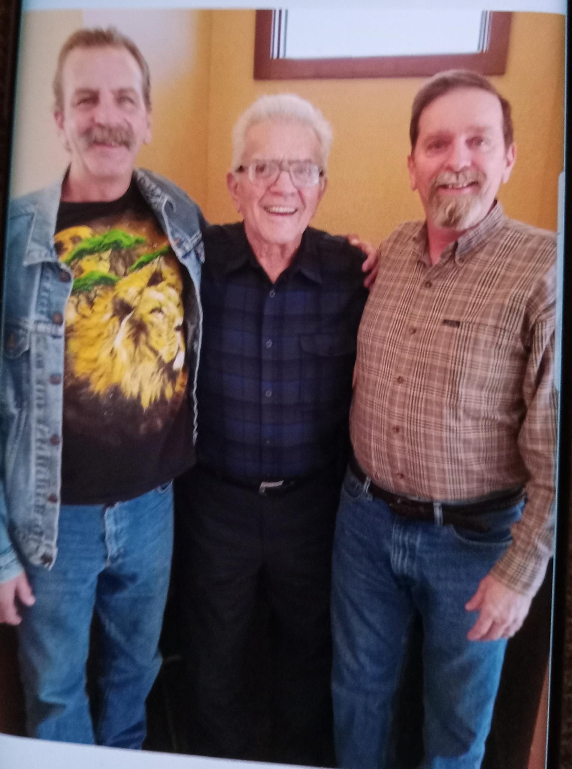 Three friends pose happily together, showcasing their camaraderie in a cheerful indoor setting.