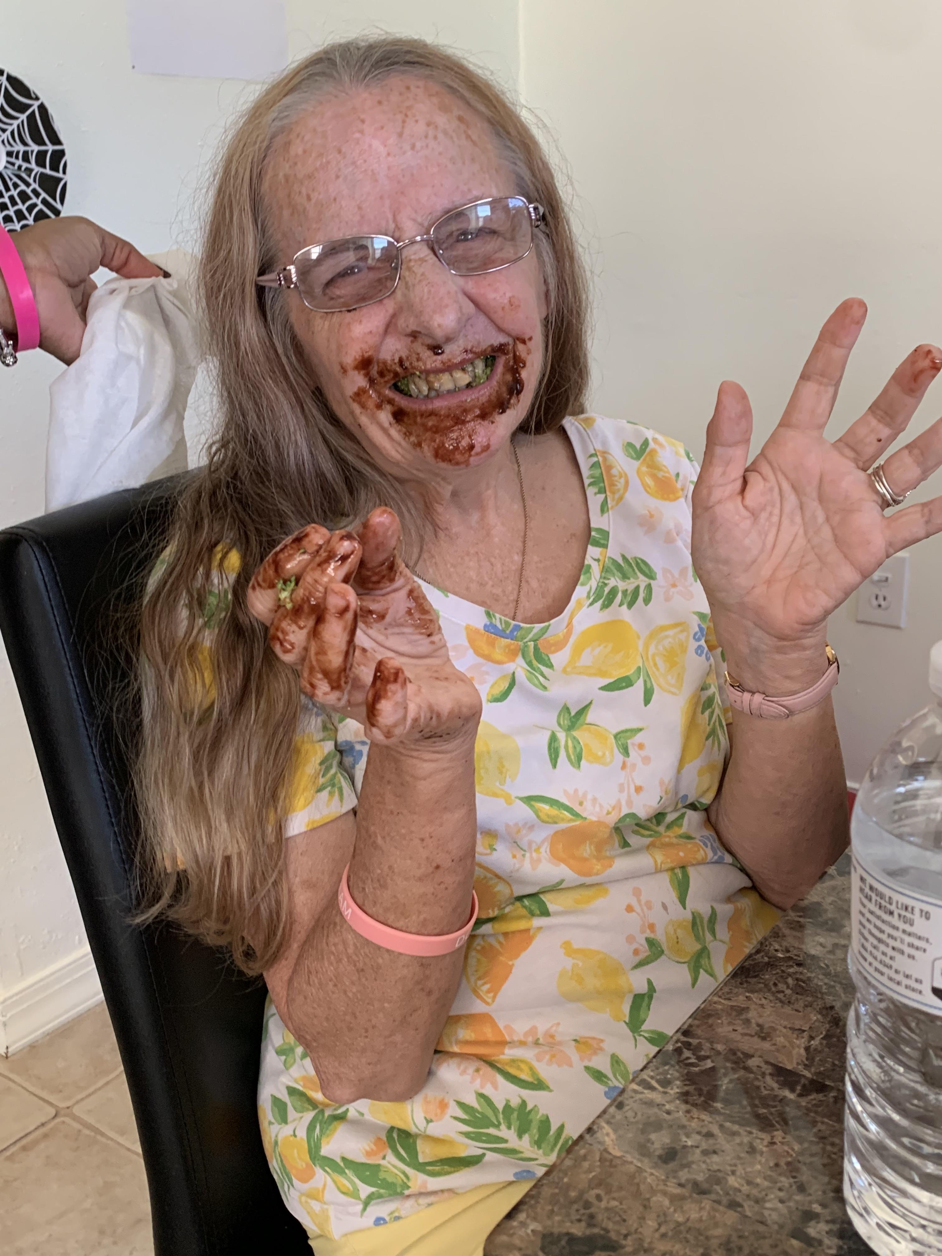 A joyful child, covered in chocolate, celebrates a birthday at home with pure delight.