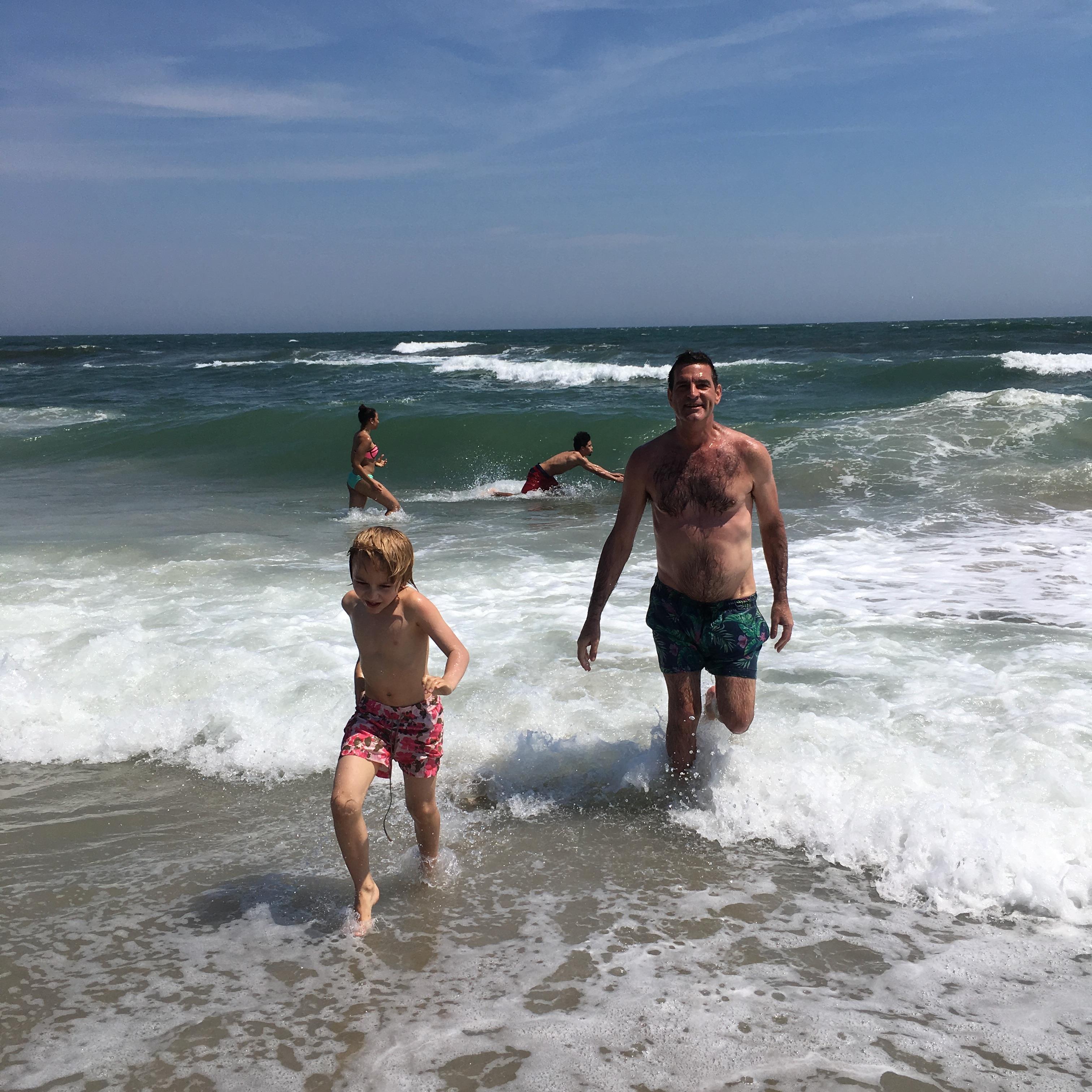 A man and boy running into the water