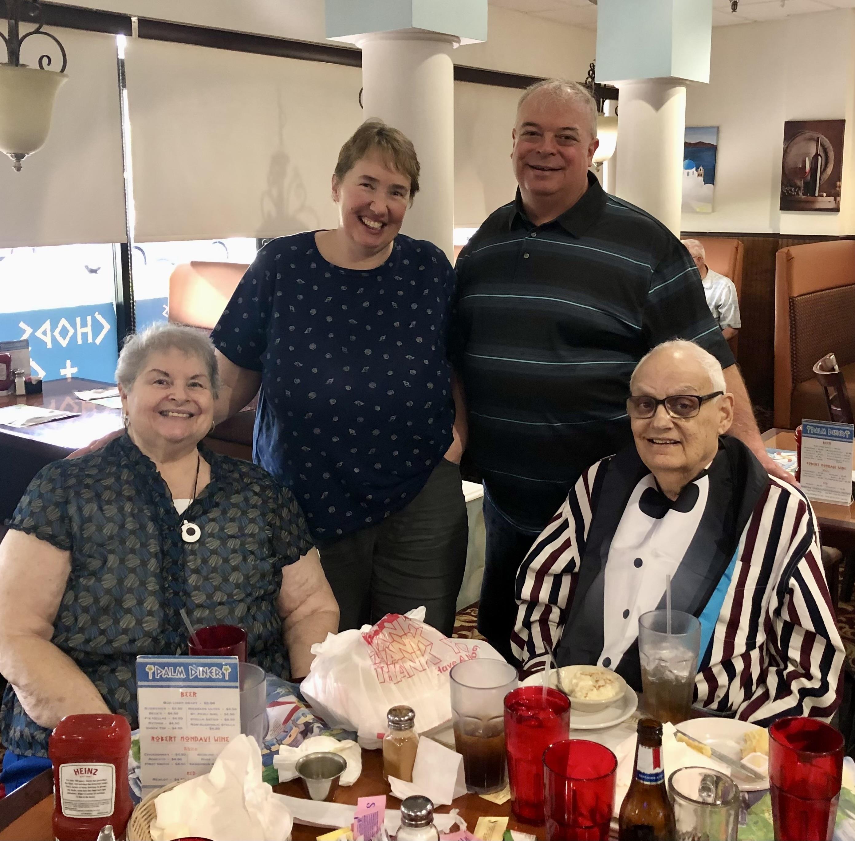 Family members enjoy a joyful gathering at a restaurant, celebrating together with food.