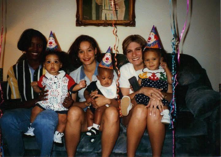 Children and adults gather, wearing party hats while enjoying a birthday celebration at home.
