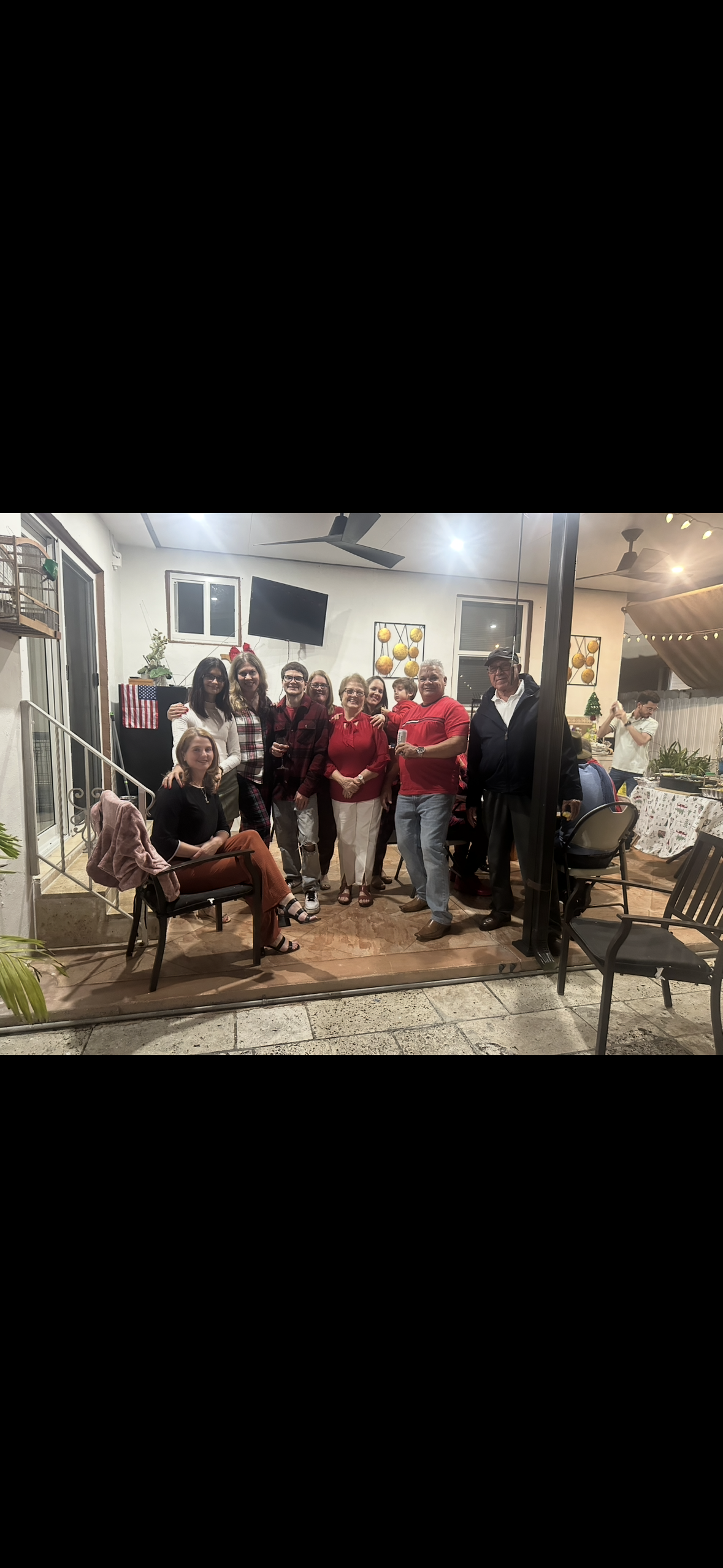 Group of smiling people enjoying a joyful celebration together in a warmly lit setting.