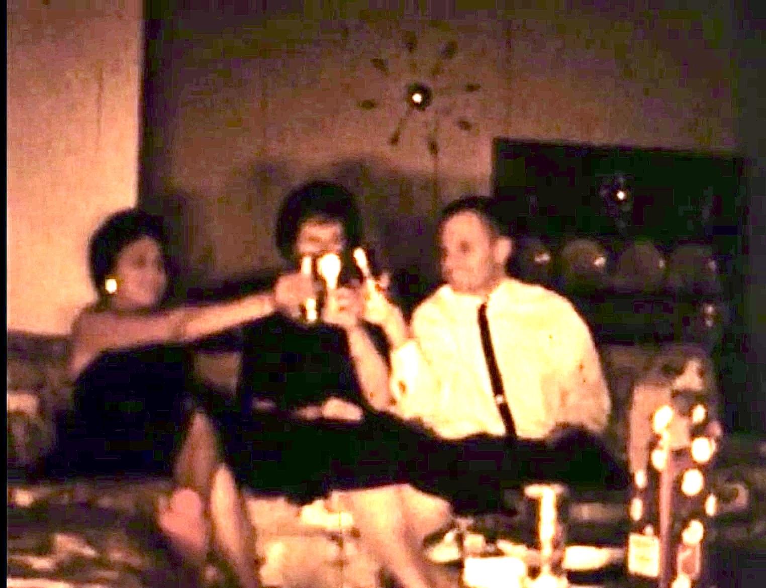 Three friends enjoy drinks and toast, creating memories during a lively indoor gathering.