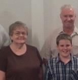 A joyful family group poses together in a warm, inviting space, celebrating a special moment.