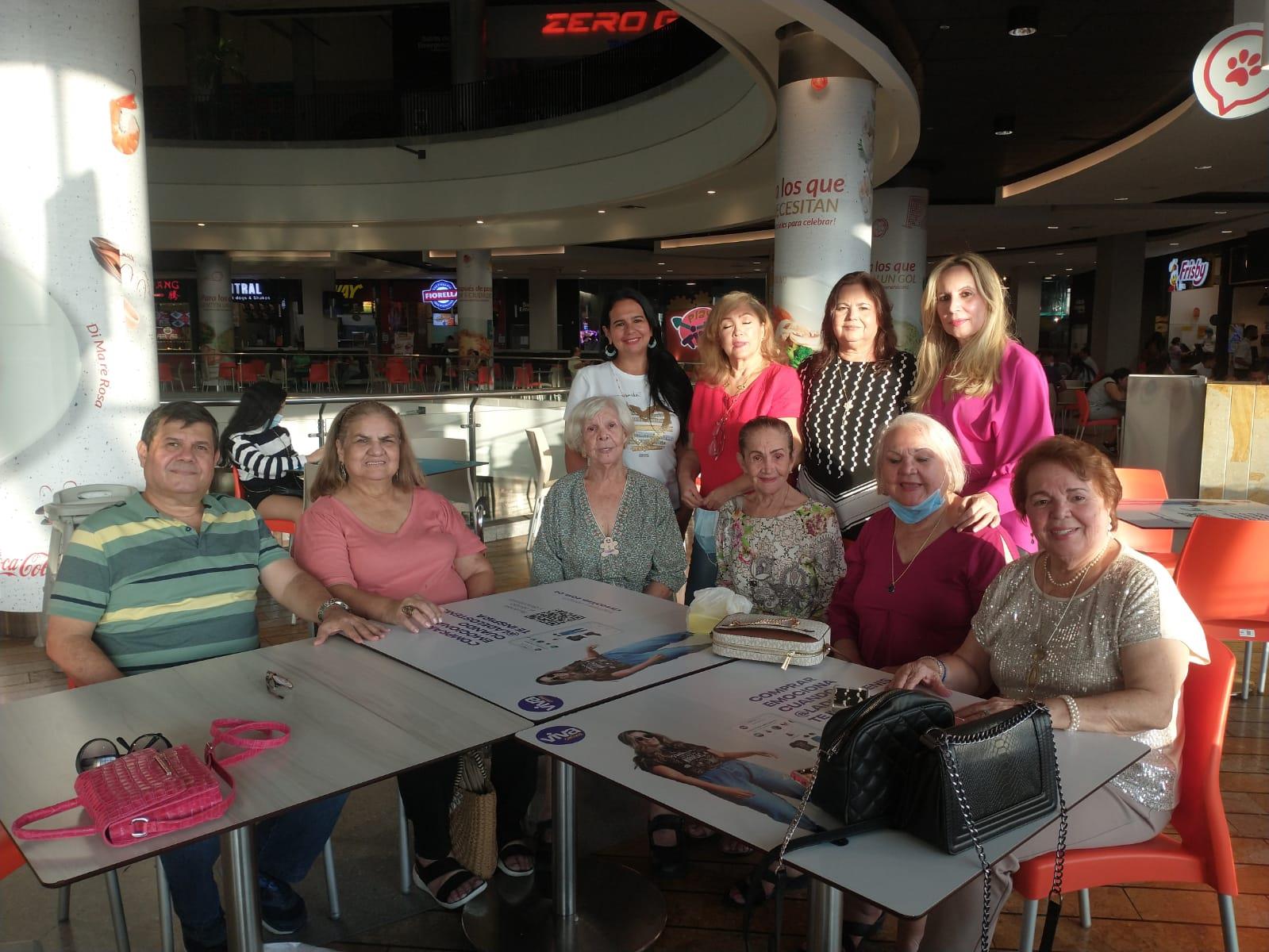 A cheerful gathering of friends at a mall enjoying each other's company during the afternoon.