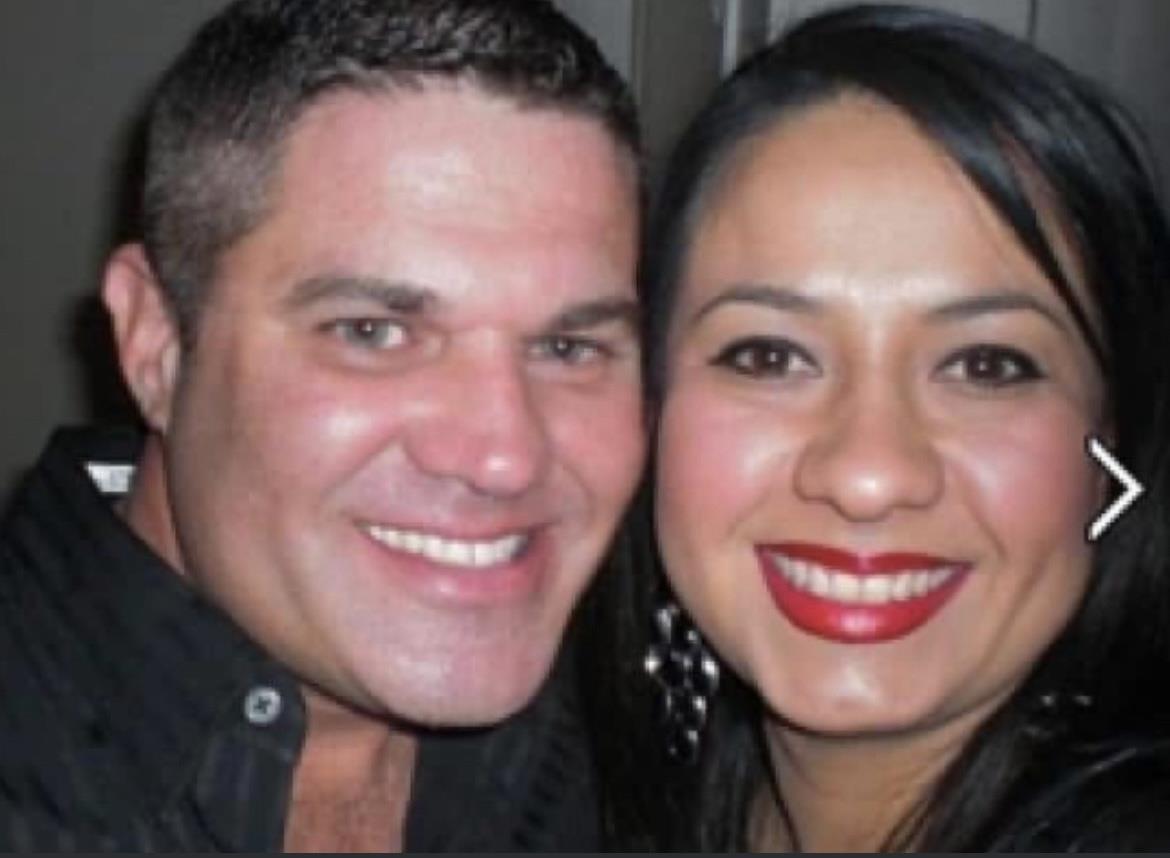 Two people are smiling widely while enjoying a lively celebration together in a close-up shot.