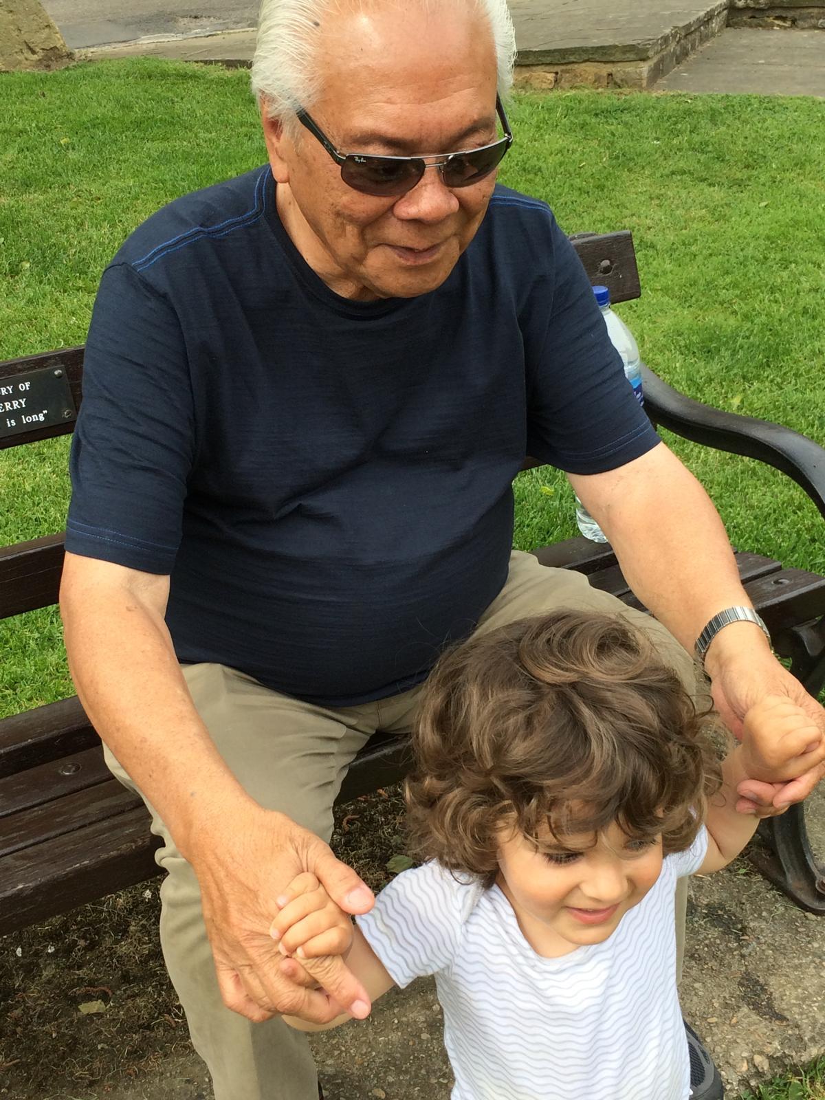 Grandfather and grandson share joyful moments at a local park, laughing and playing together.