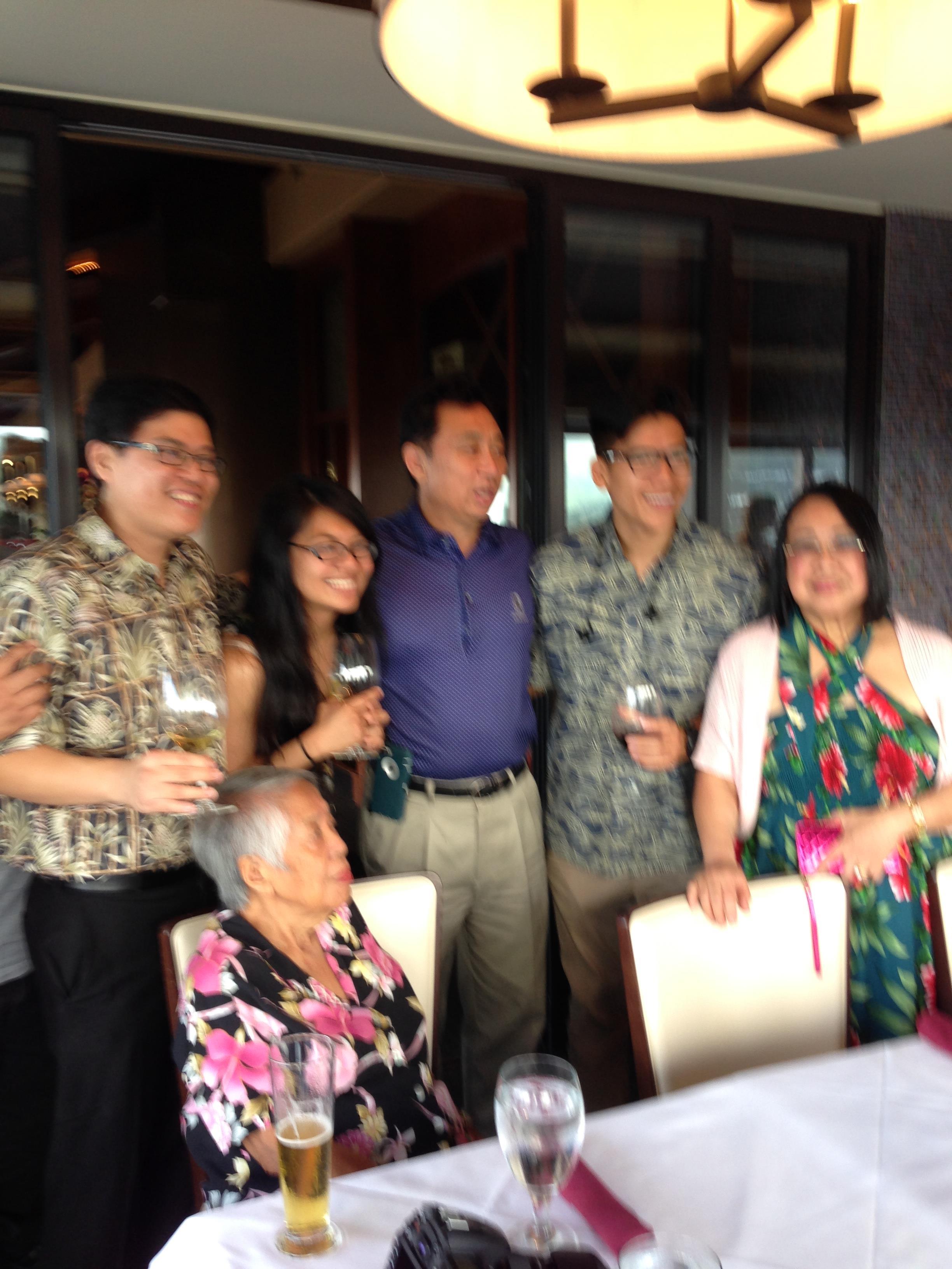 Family members enjoy drinks and smiles while celebrating an event at a restaurant together.