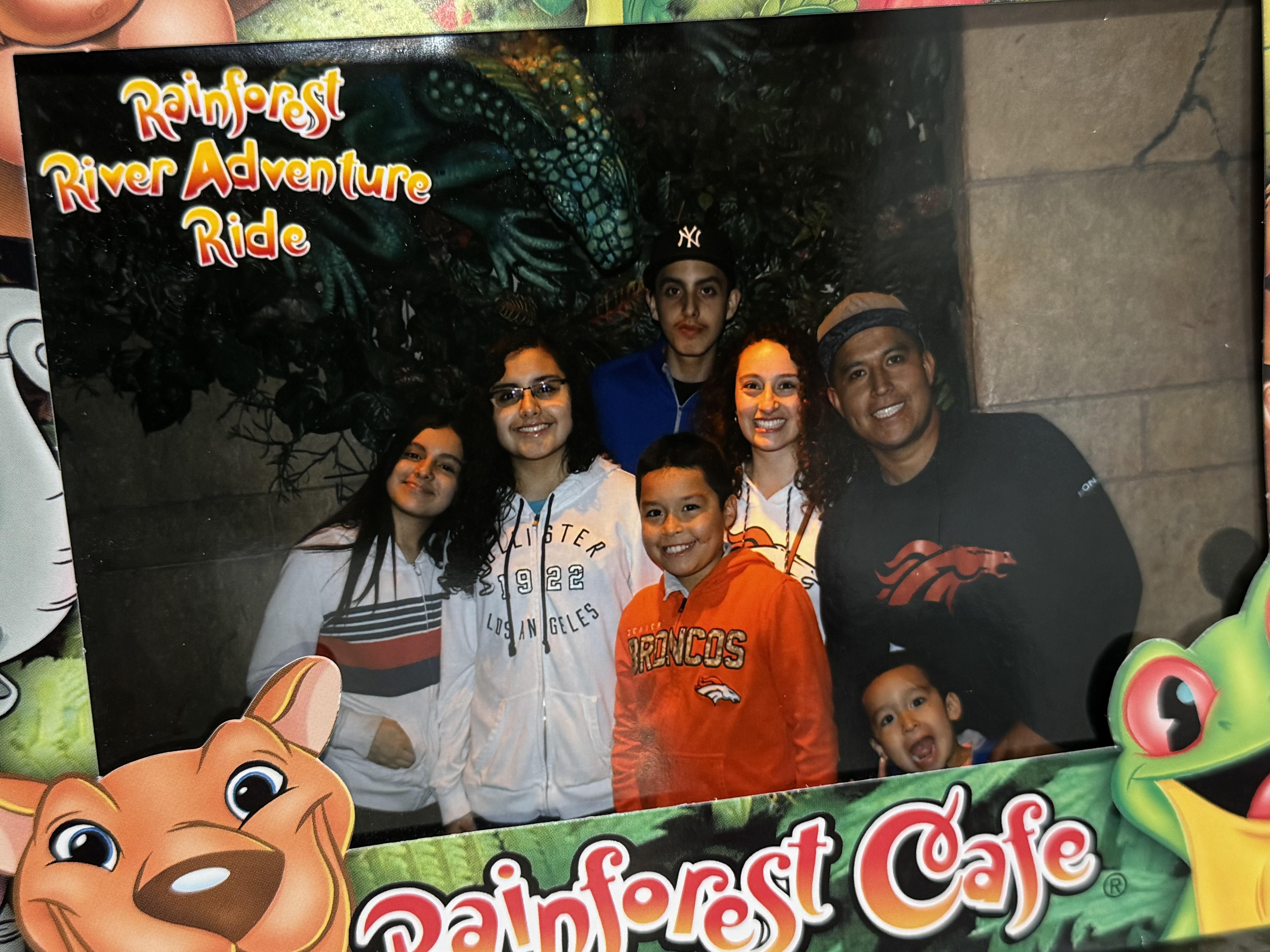 A group of happy individuals smiles together at a themed eatery during a fun outing.