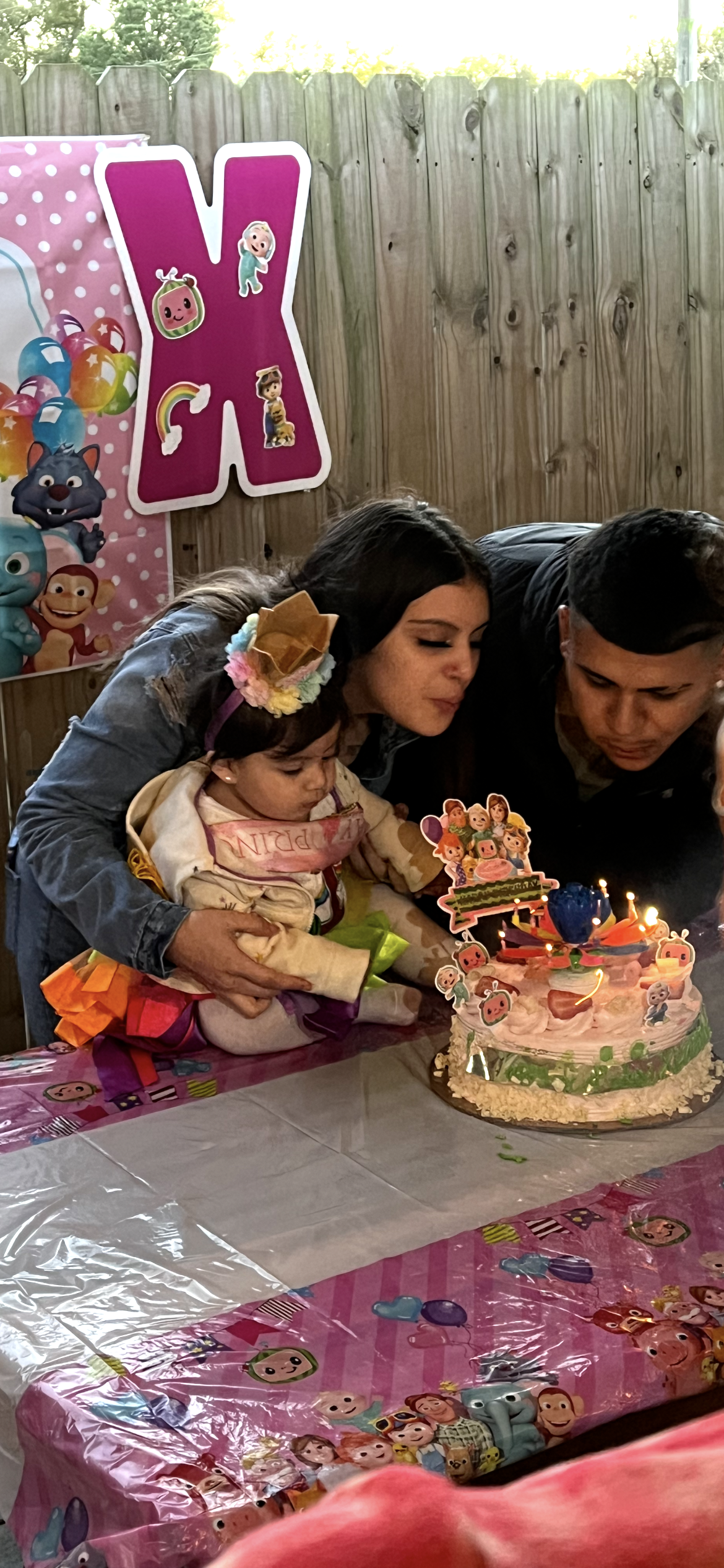 Family gathers around a decorated cake to celebrate a young child's birthday with joy.