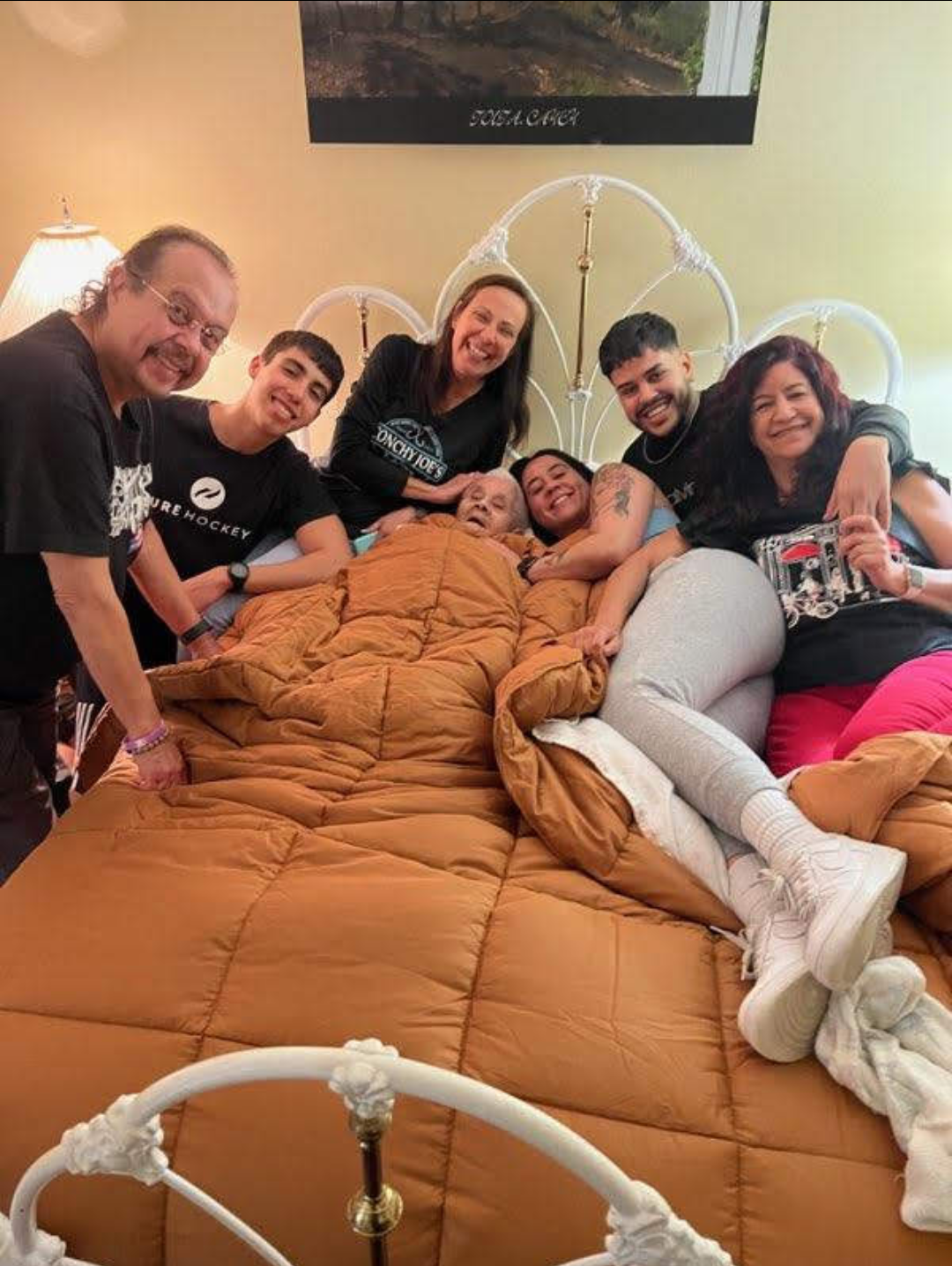 Family members joyfully gather in a bed, sharing love and smiles in a cozy setting.
