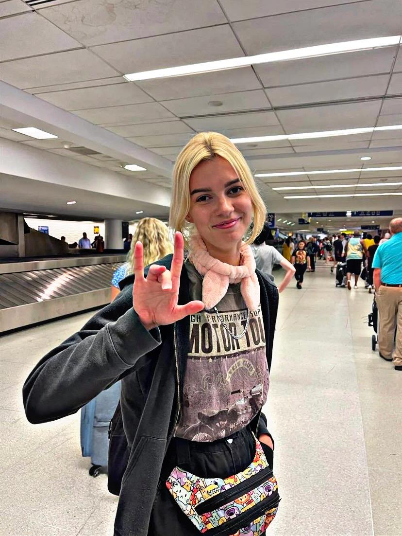 A woman holding up her hand in a airport