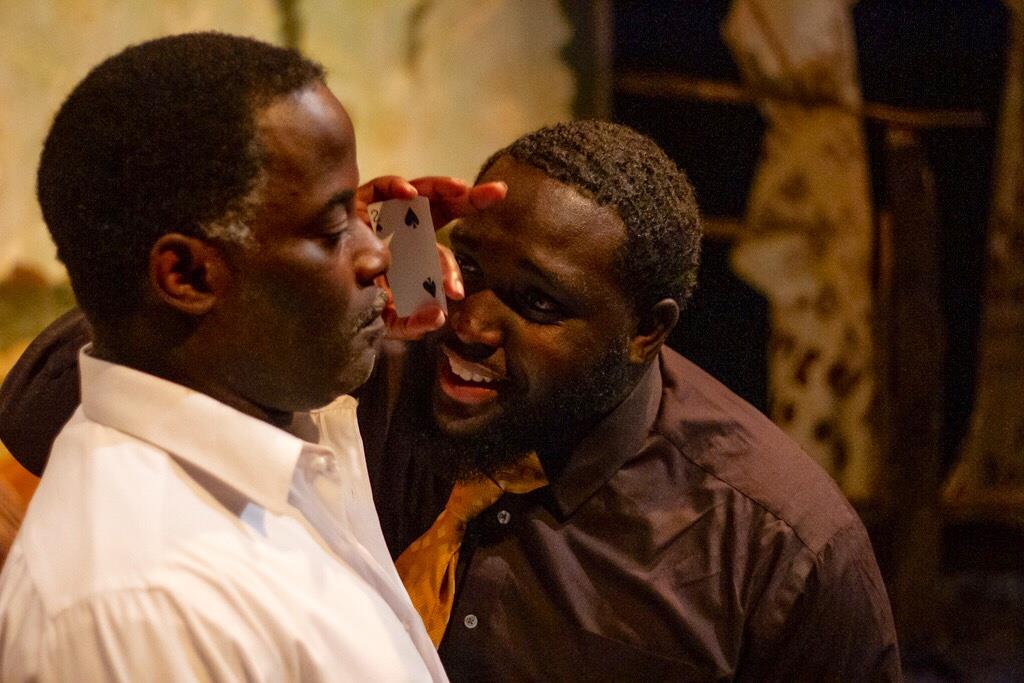 Two men argue passionately in a dark setting, hinting at underlying tension.