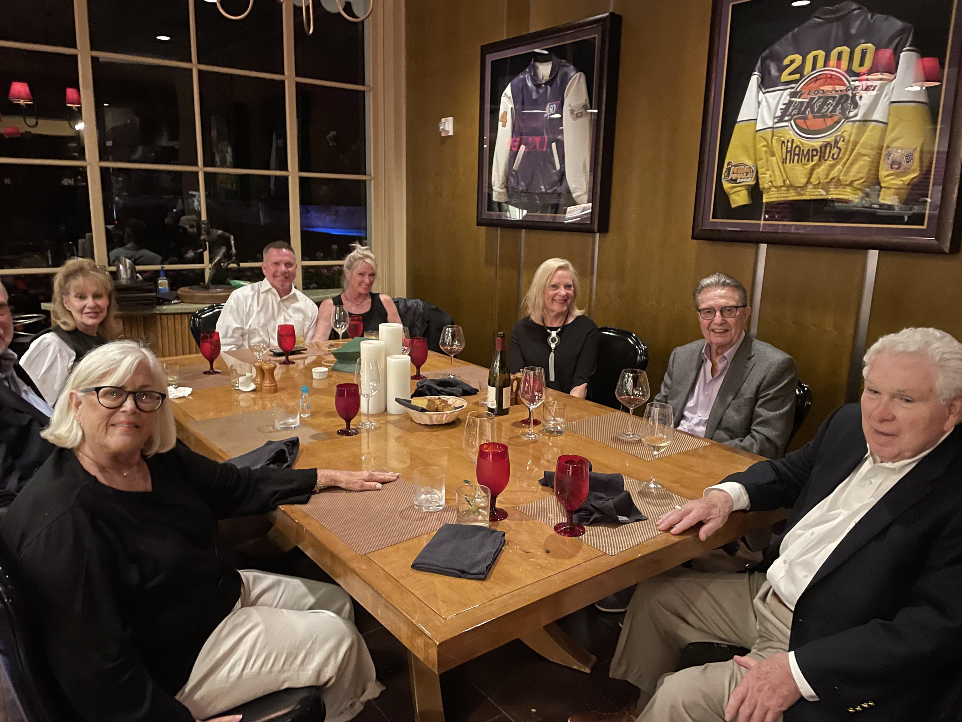 Friends gather around a large wooden table, sharing laughter and conversation over dinner.