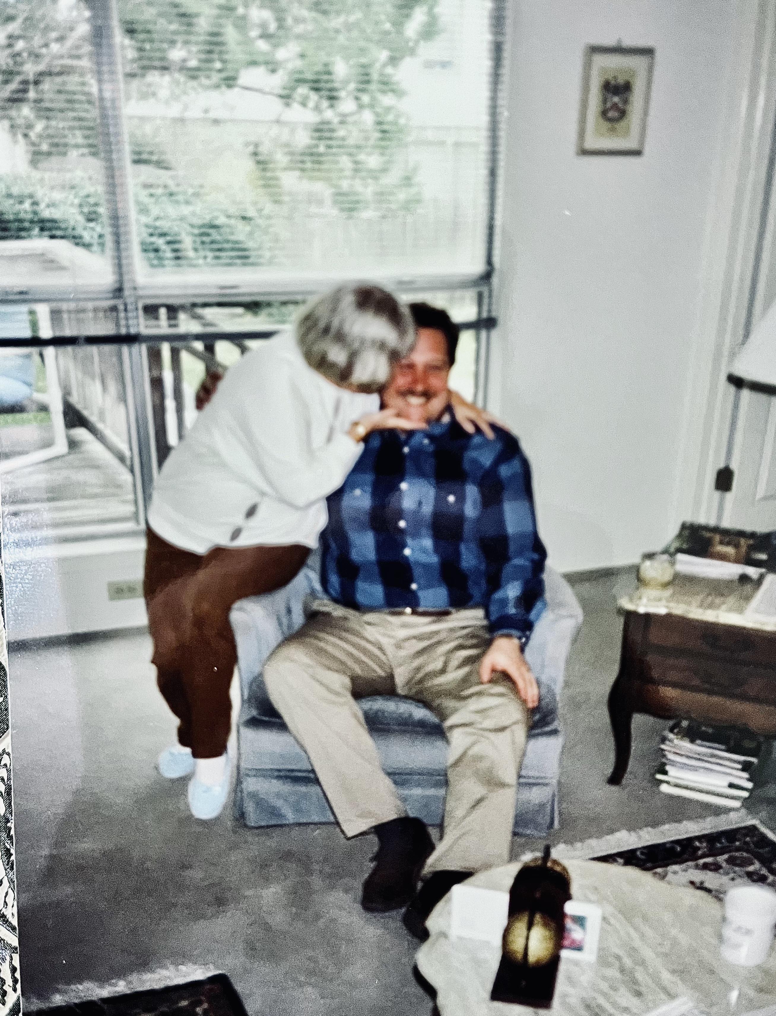 Elderly couple enjoys a playful interaction in a bright living room filled with warmth.
