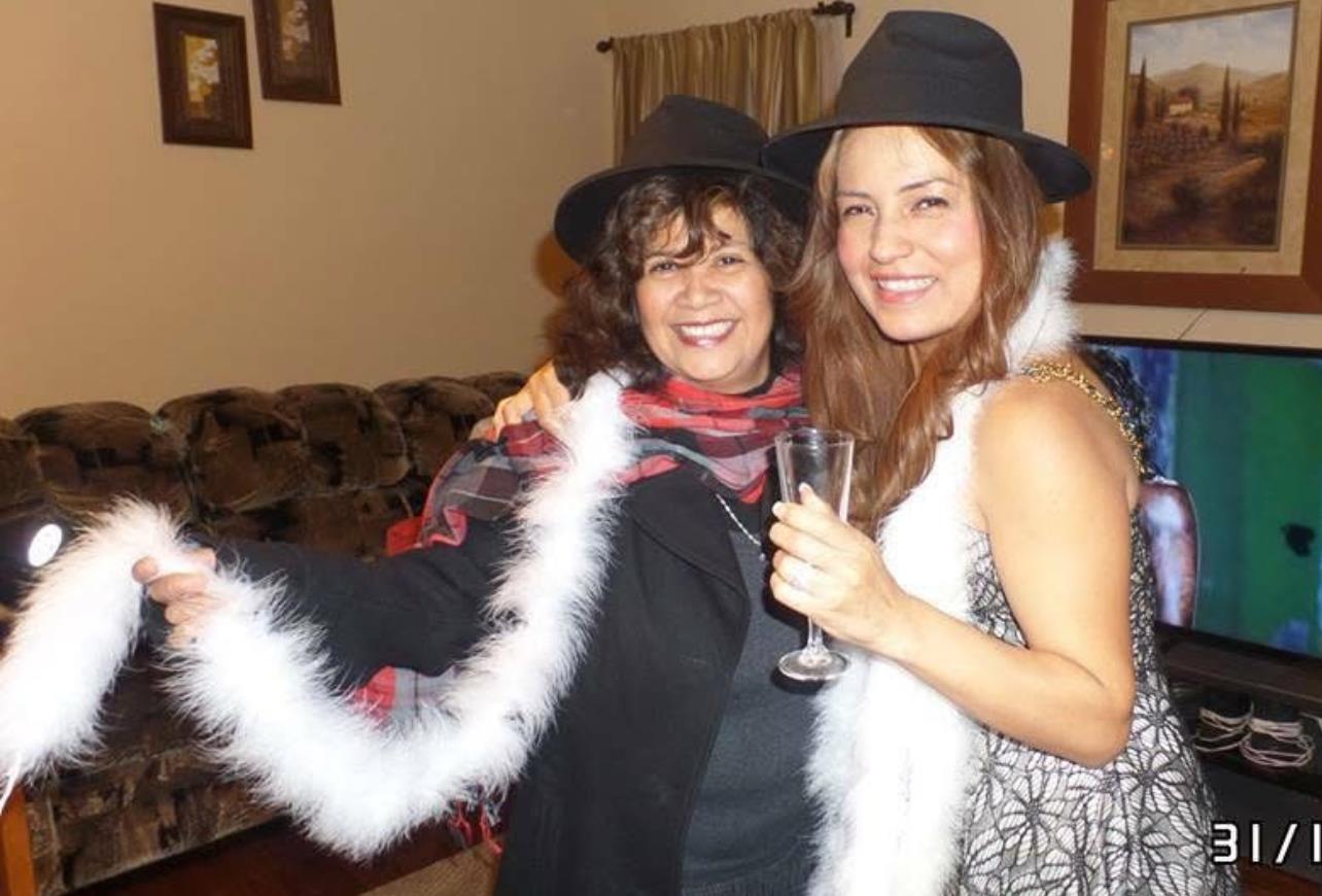 Two friends celebrate in festive attire at a cozy indoor gathering.