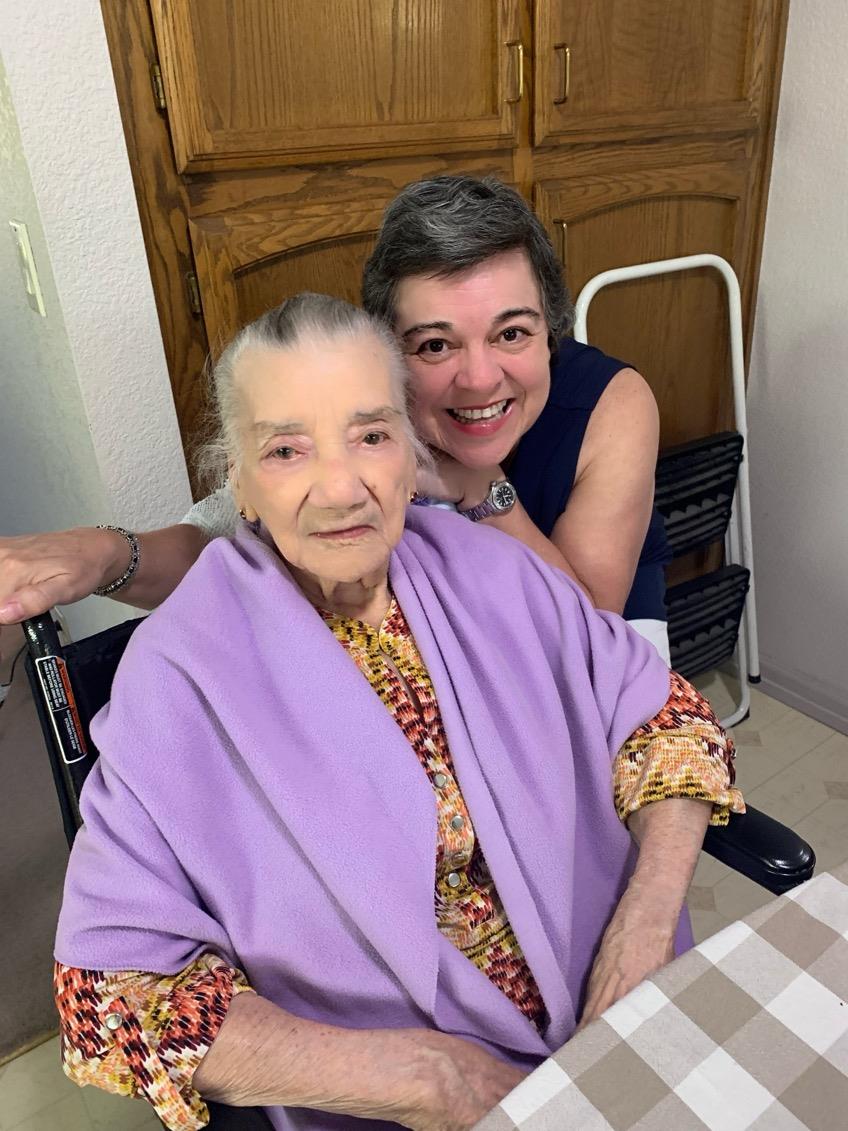 Caregiver and elderly woman share a happy moment together at home, enjoying each other's company.