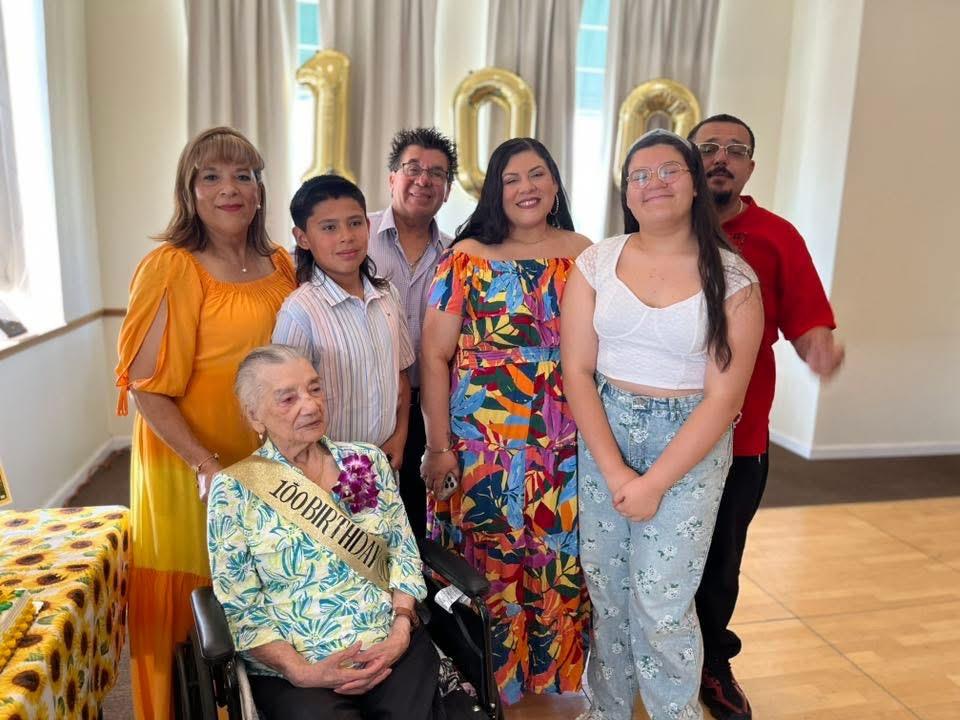 Loved ones gather to joyfully celebrate a 100th birthday in a festive venue.