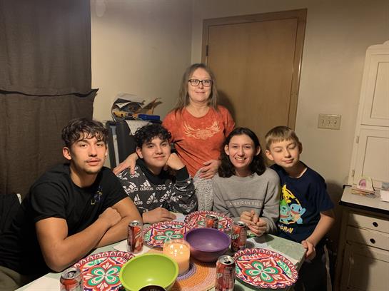 A group of people sitting at a table with plates and cans