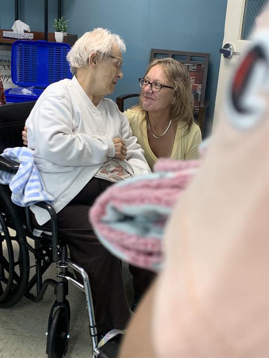 A woman talking to a woman in a wheelchair