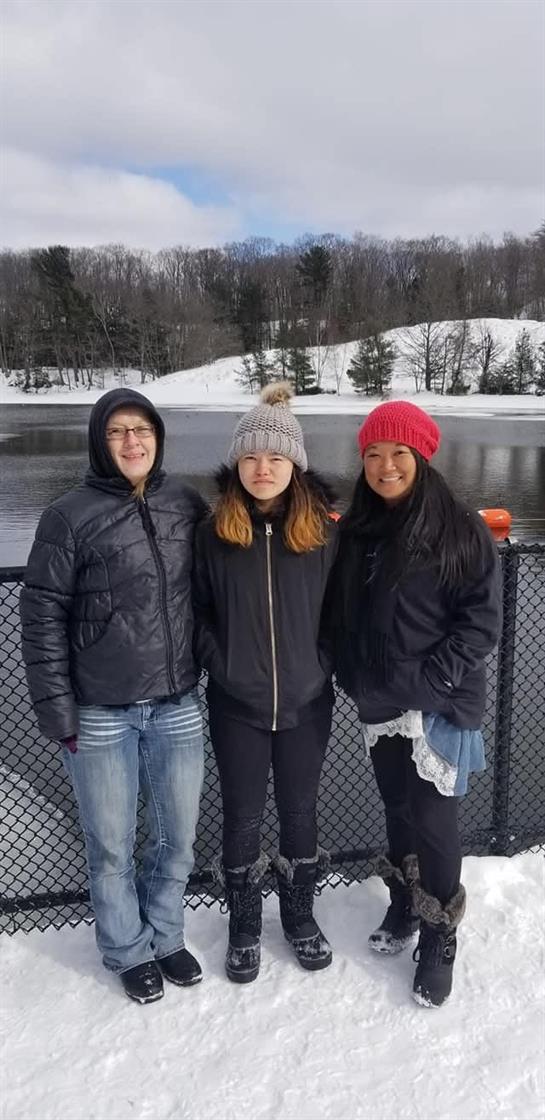 A group of women standing in front of a lake