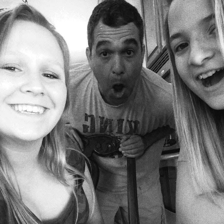 A group enjoys laughter and smiles while cooking together in a bright kitchen.